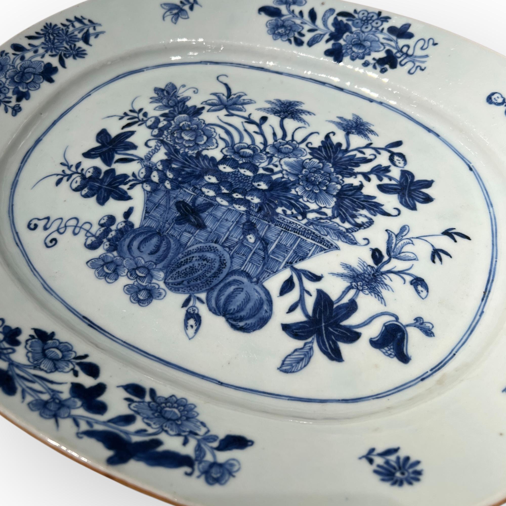 Dieser Porzellanteller aus der Zeit um 1760 zeigt ein exquisites Design mit einem Korb, der mit zarten Blumen verziert ist. Die glatte Oberfläche und die raffinierten Pinselstriche zeugen von der Kunstfertigkeit der Jingdezhen-Künstler, deren