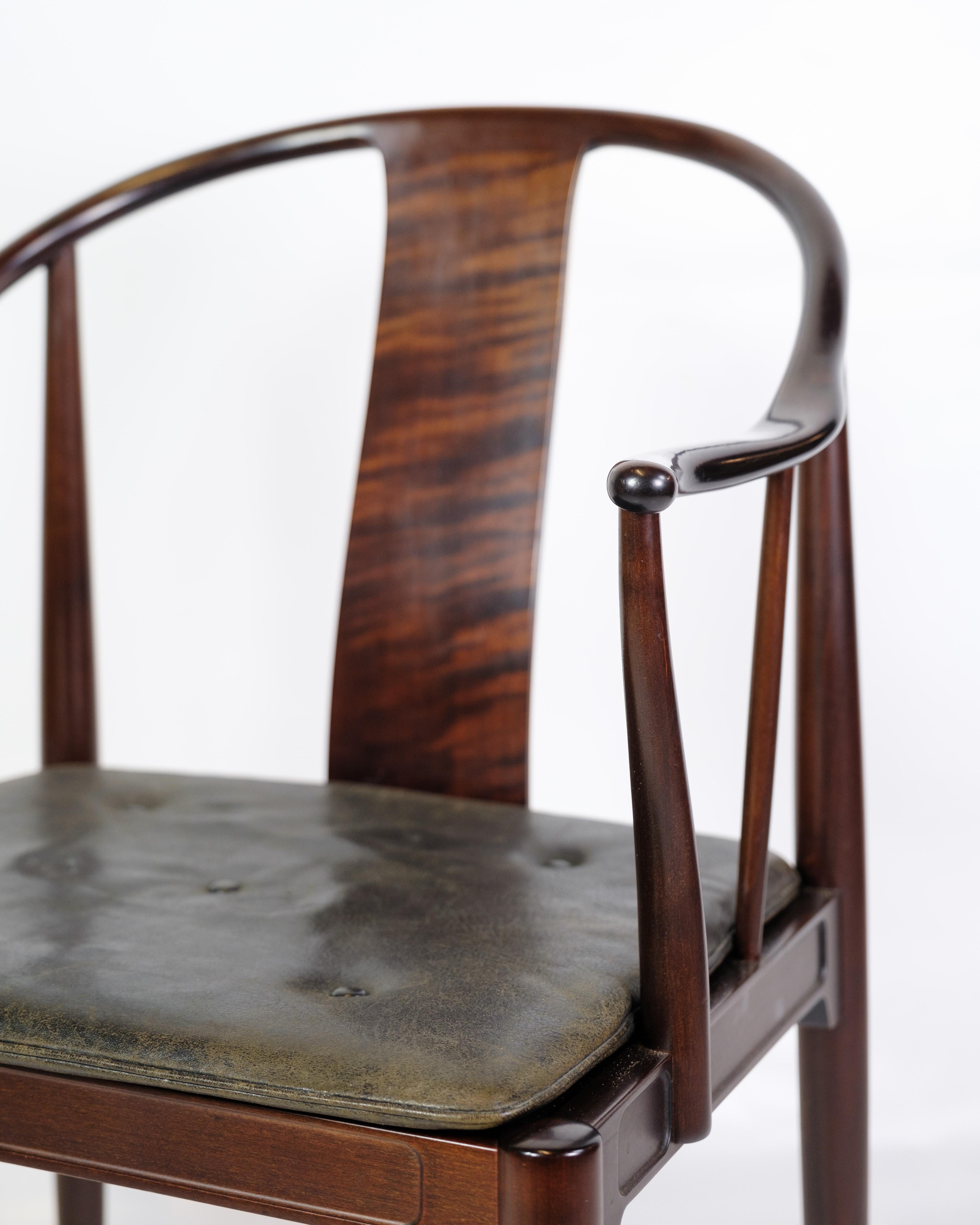 The China Chair, model FH 4283, designed by Hans J. Wegner and produced by Fritz Hansen in the 1950s, is made of dark wood with an original black leather upholstered seat. The chair is inspired by classical Chinese furniture, which can be seen in