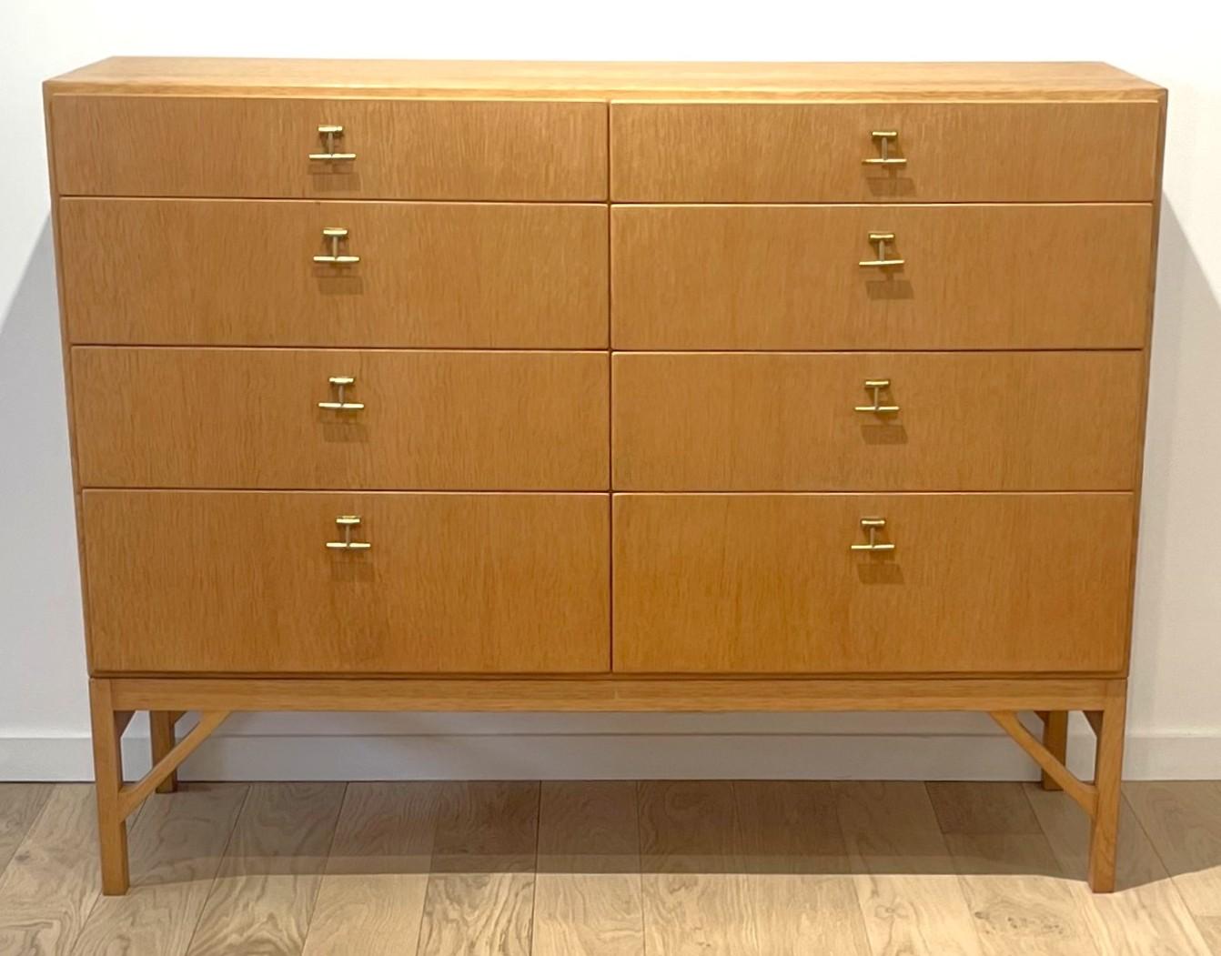 Børge Mogensen is known for his simple and functional design. This is the case of this beautiful China Chest piece: its legs (original) inspired by Chinese furniture, its thin brass handles and the pretty honey colour of the oak give it elegance in