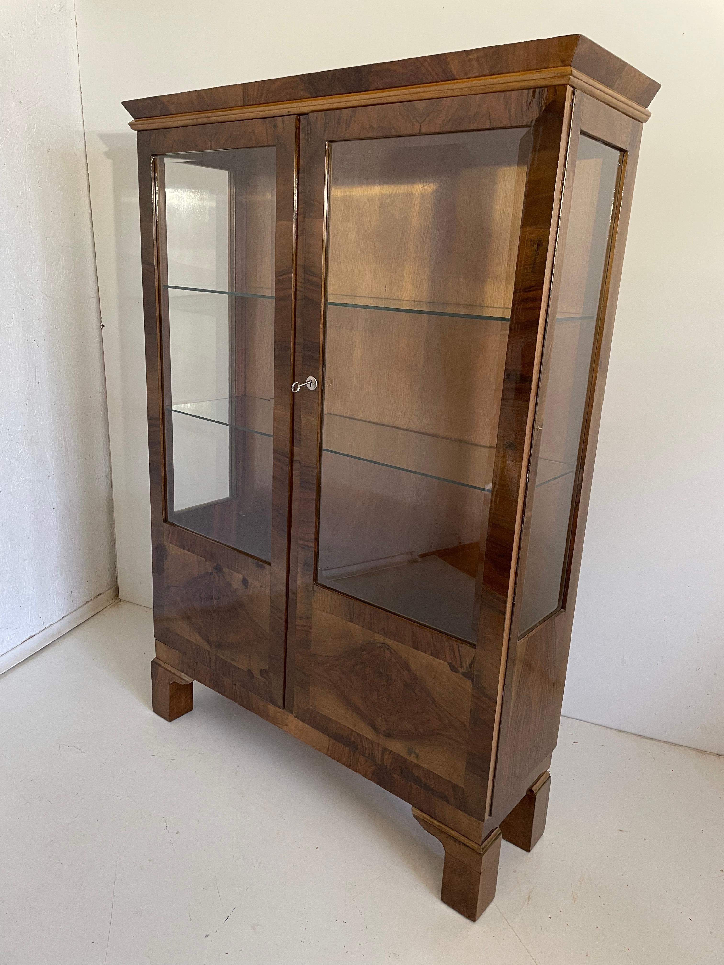 We present a made to order unique designer Art Deco showcase from 1950

It has been cleaned to bare veneer, disinfected and finished by hand with high gloss shellac polish.

Every piece of furniture that leaves our workshop from the beginning to the