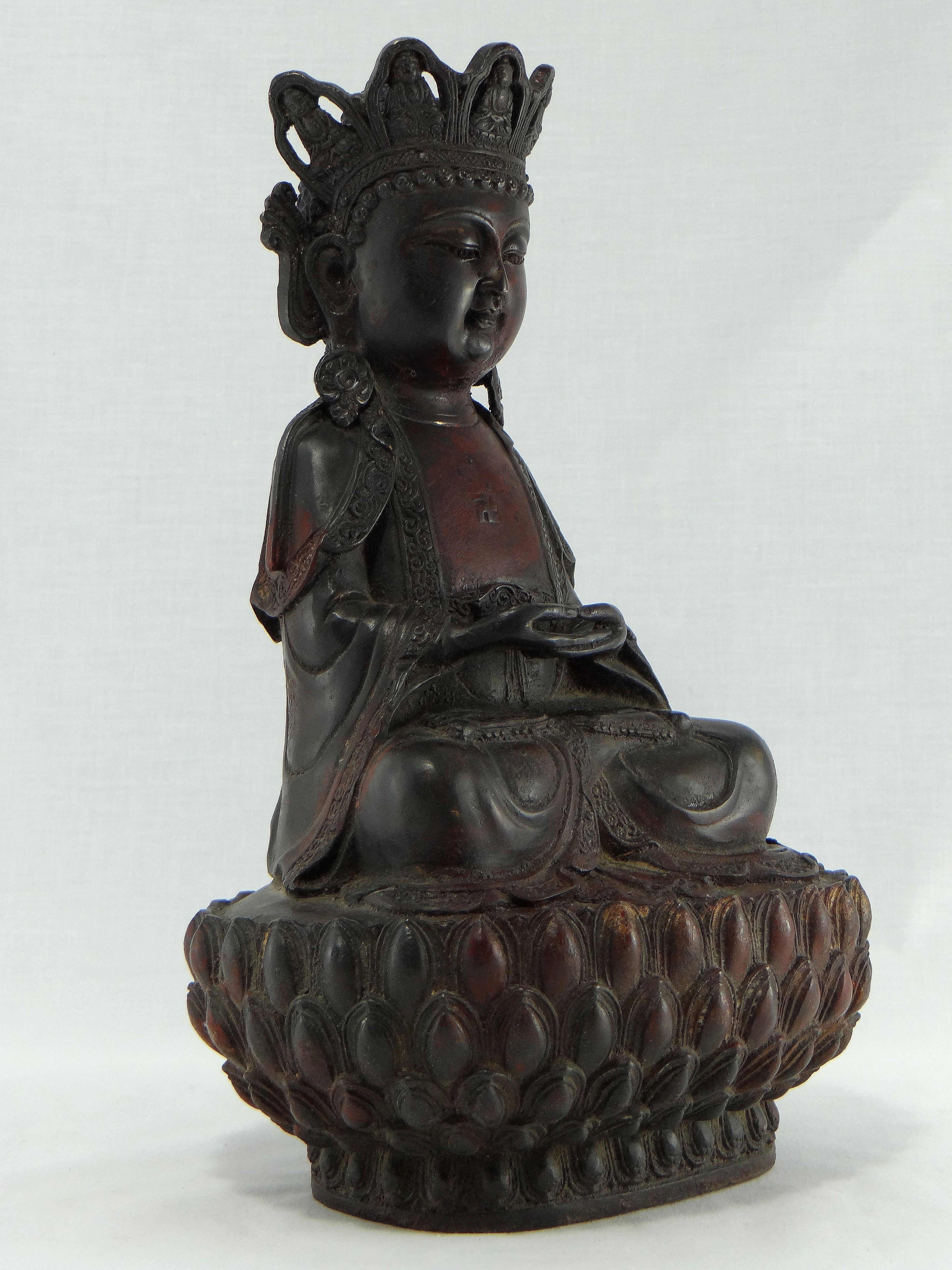 South China, 18th century in the style of Ming, superb bronze statuette formerly lacquered red representing a bodhisattva sitting in meditation on a lotus, hands joined, wearing a tiara decorated with reminiscence of the Buddha, a swastika on the