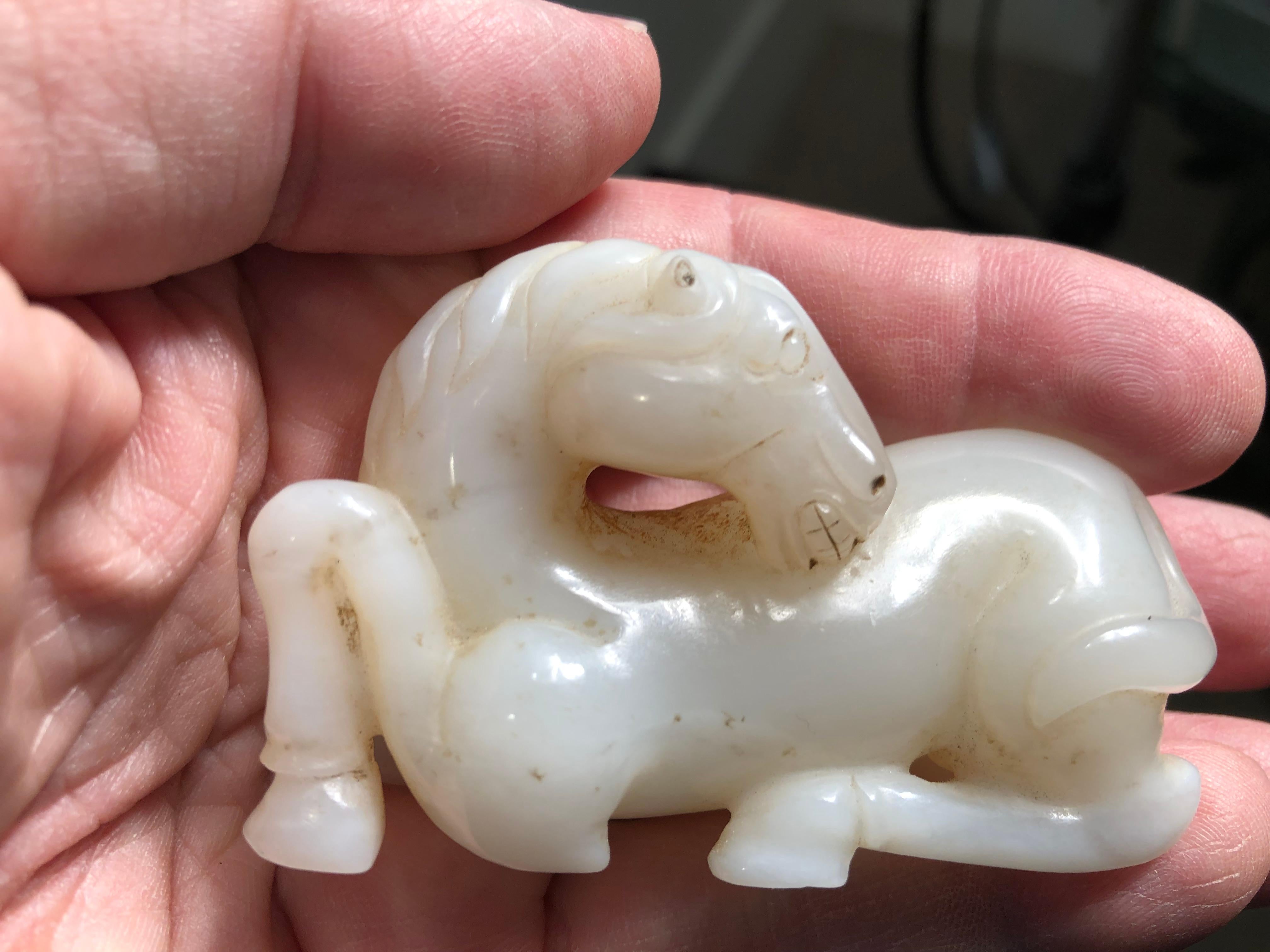 China, a finely carved antique white jade of a recumbent horse- a significant jade ornament with patina from good age. Qing dynasty, 19th century. 

Lovely details. A genuine pleasure to hold and touch with a light brown calcified color on its