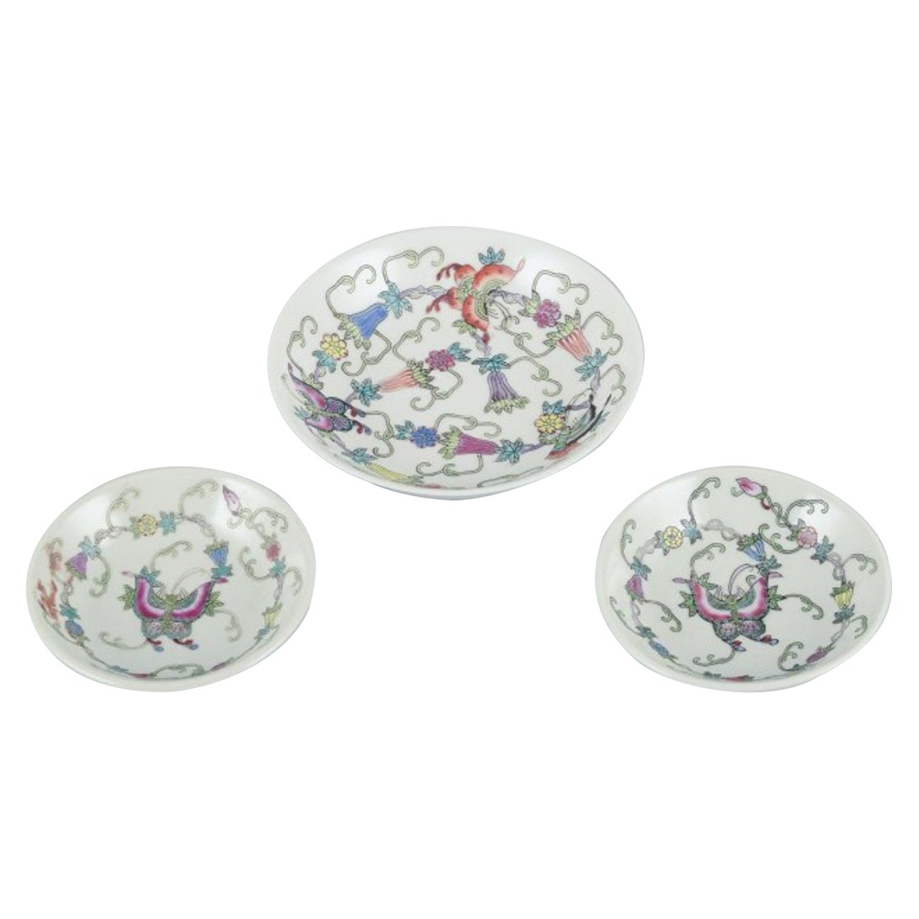 China, tres cuencos de porcelana. Motivos clásicos con flores y mariposas.