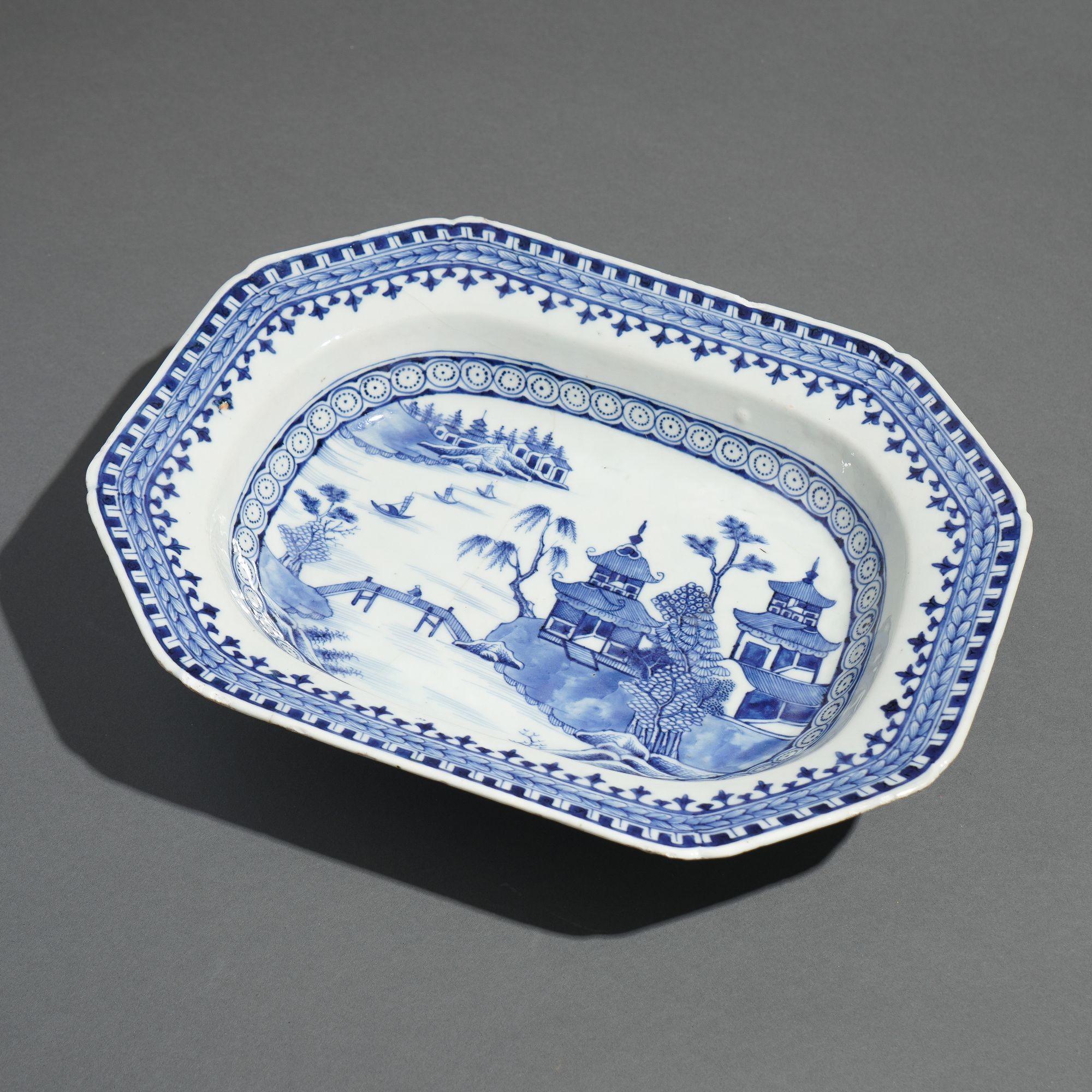Octagonal porcelain deep platter decorated in the traditional Chinese tea house motif with a Nanking arrow border in underglaze cobalt blue. A fine firing line appears on the underside, and glazing chips appear along the rim.

China, made for the