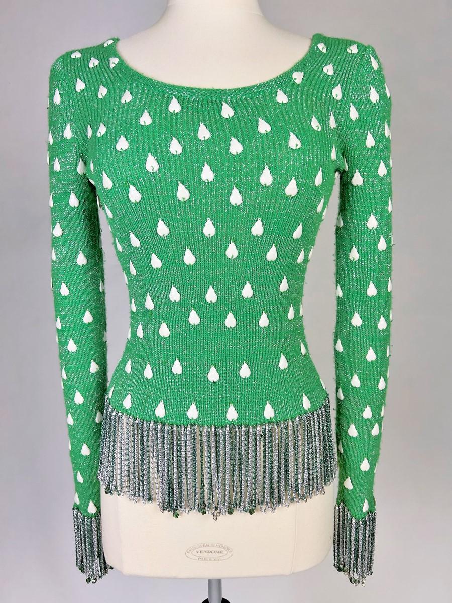 Circa 1980-1990

France

Pull de soirée original en stretch de Loris Azzaro (attribué à) datant des années 1980. Pull moulant à encolure bateau et manches longues en maille de laine chinée vert pomme et lurex argenté. Des pastilles en plastique
