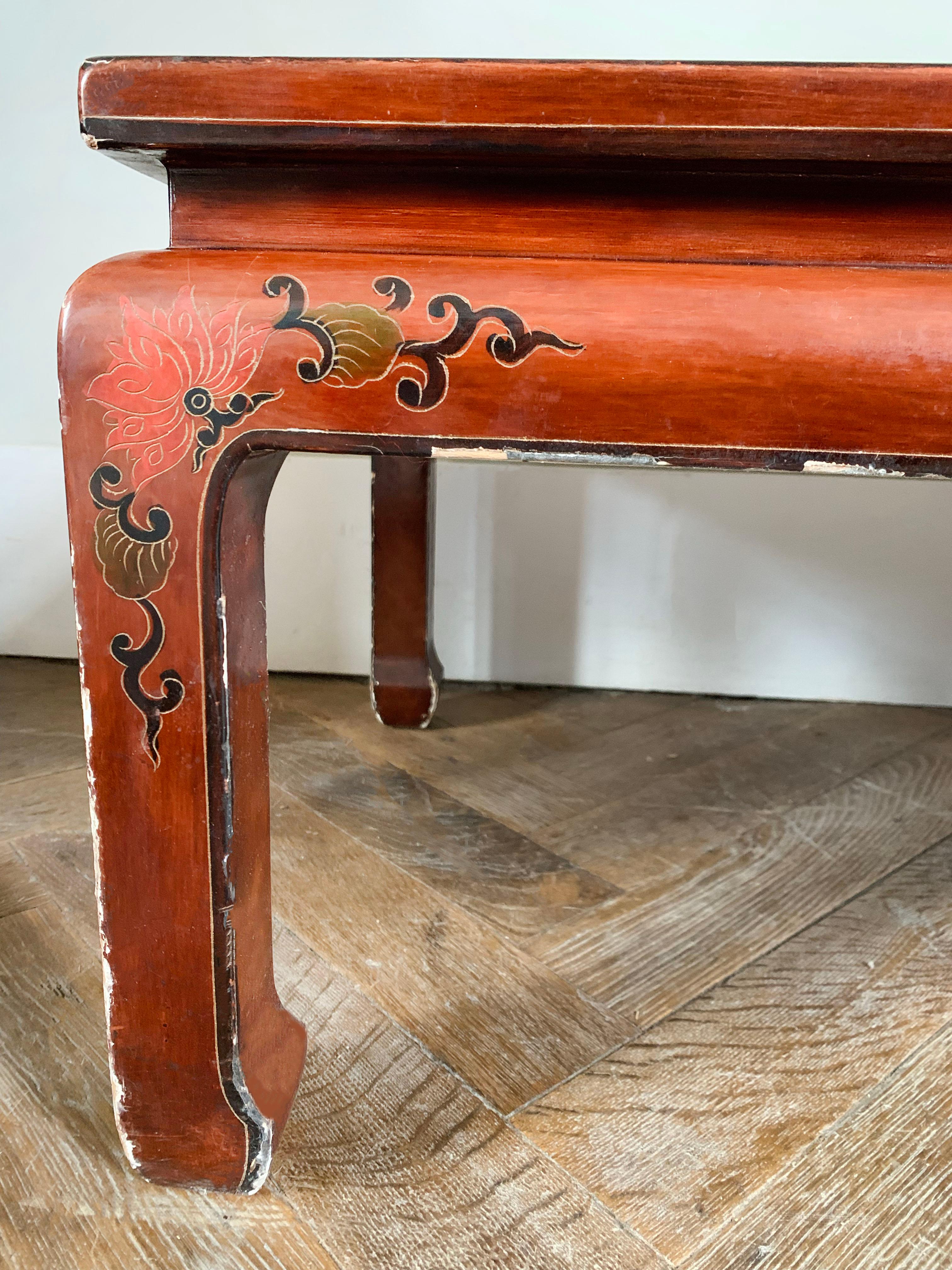 Nice rectangular Chinese red lacquer coffee table. The legs are straight. The top is decorated with branches, flowers and birds. The edge of the table top is decorated with plant motifs. 
China 
Circa 1950.