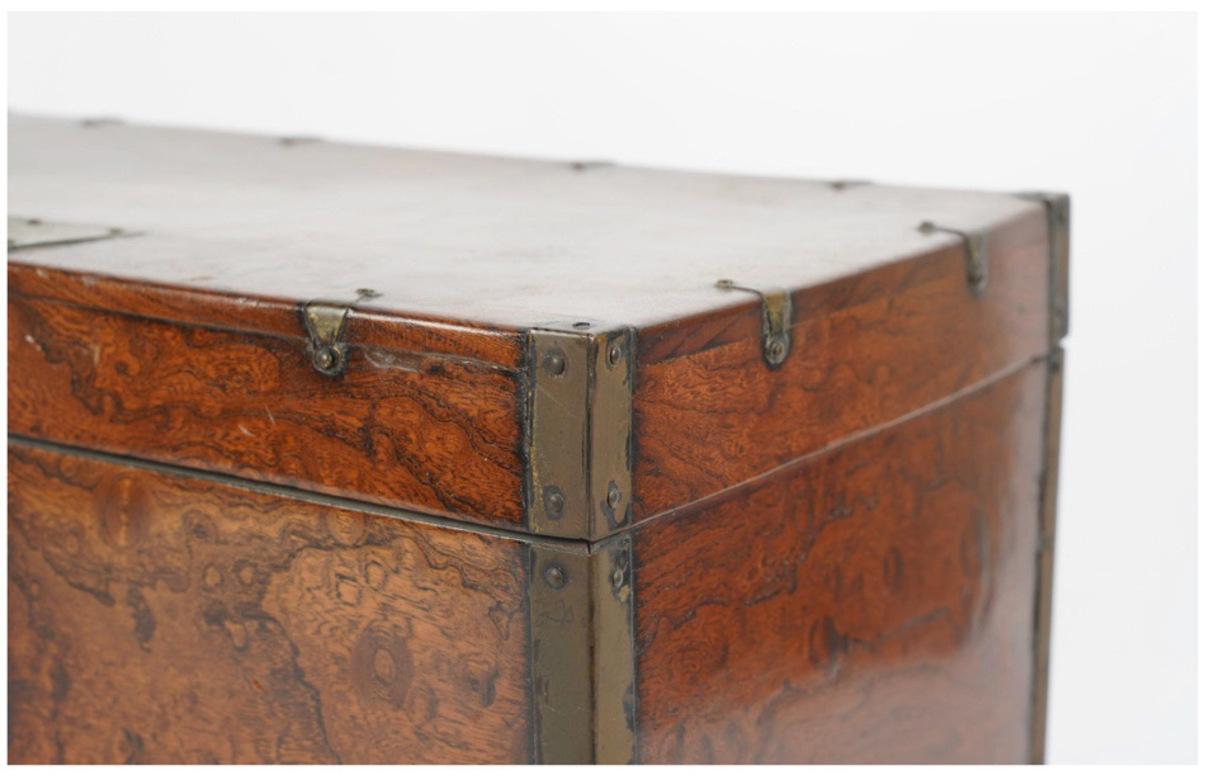 This is a quietly impressive Chinese mid-to-late 19th century table or writing box. The box is of metal-mounted burl wood construction in the Ming style, but dating later. The box features a hinged lid over a well with tray over a drawer and is