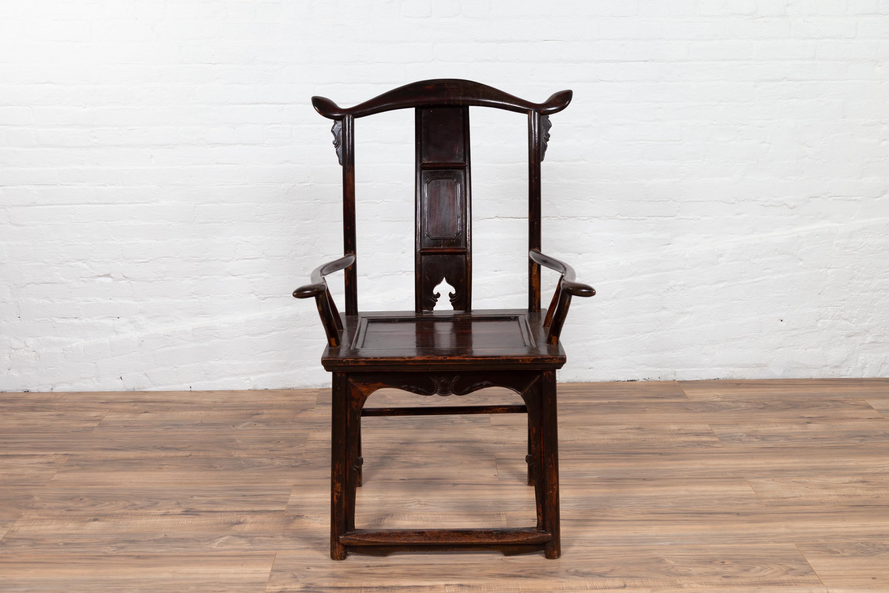 A Chinese antique Qing dynasty scholar's lamp-hanger armchair from the late 19th century, with sinuous pierced splat, dark patina, curving arms and side stretchers. Born in China in the later years of the 19th century, this scholar's lamp-hanger
