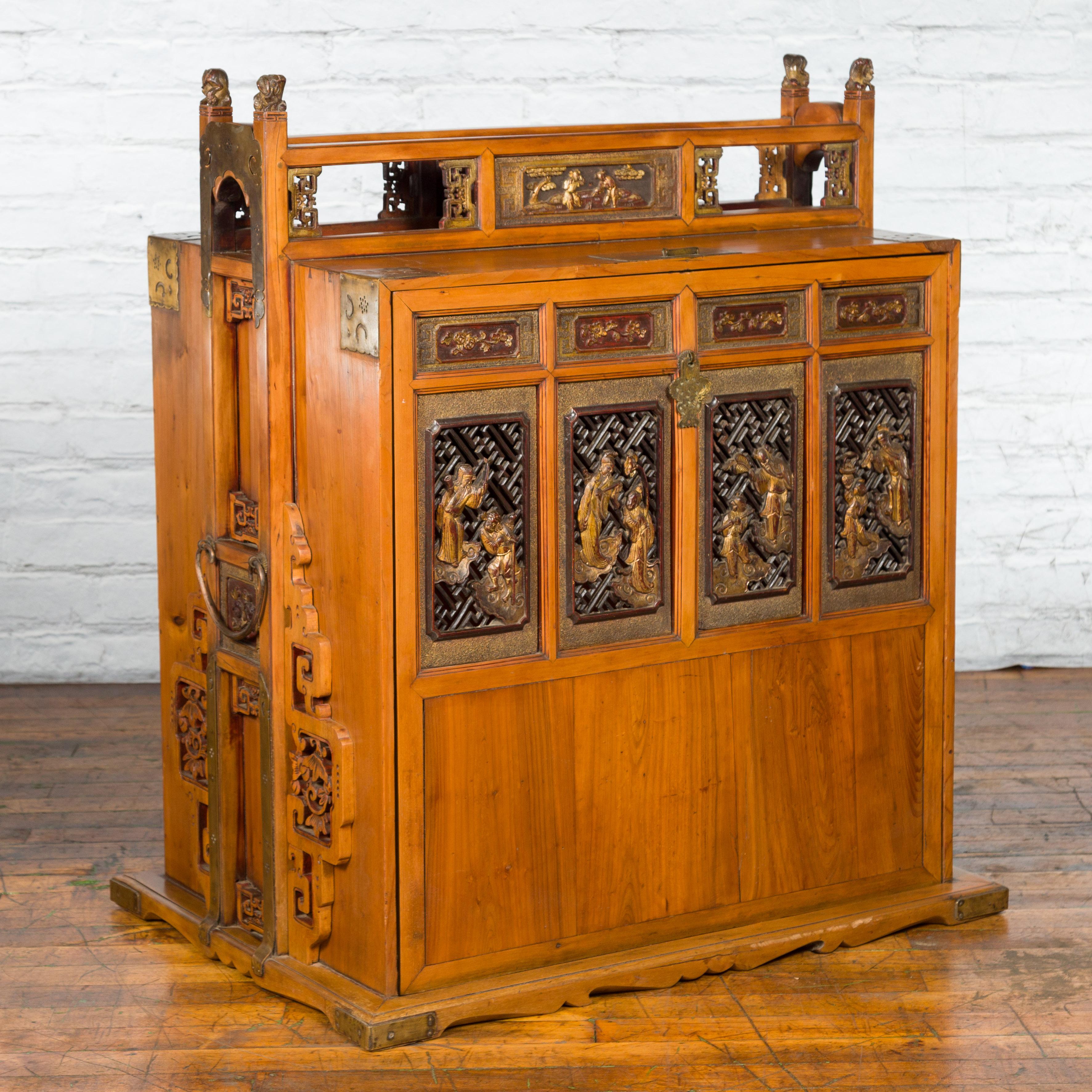 A Chinese Qing Dynasty period dowry chest from the 19th century, with fretwork, carved giltwood characters and brass ornaments. Created in China during the Qing Dynasty, this dowry chest features a linear wooden structure, beautifully accented with