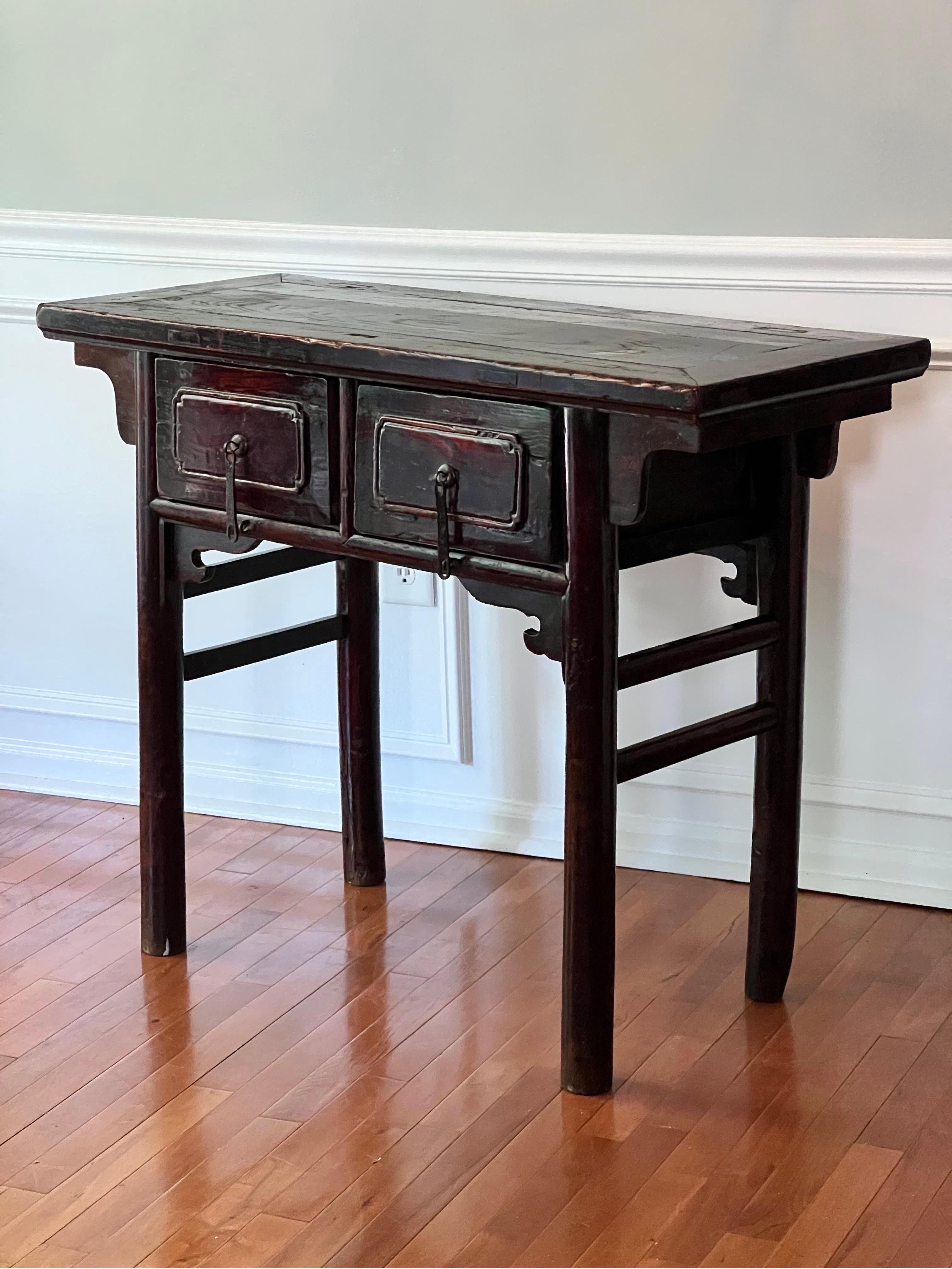 Exquisite antique Chinese lacquered elm Alter table, 19th century.

Richly hued in tones of wine and deep brown with great patina, this lacquered table features two deep drawers with unique, original hammered iron hardware pulls and straight, round