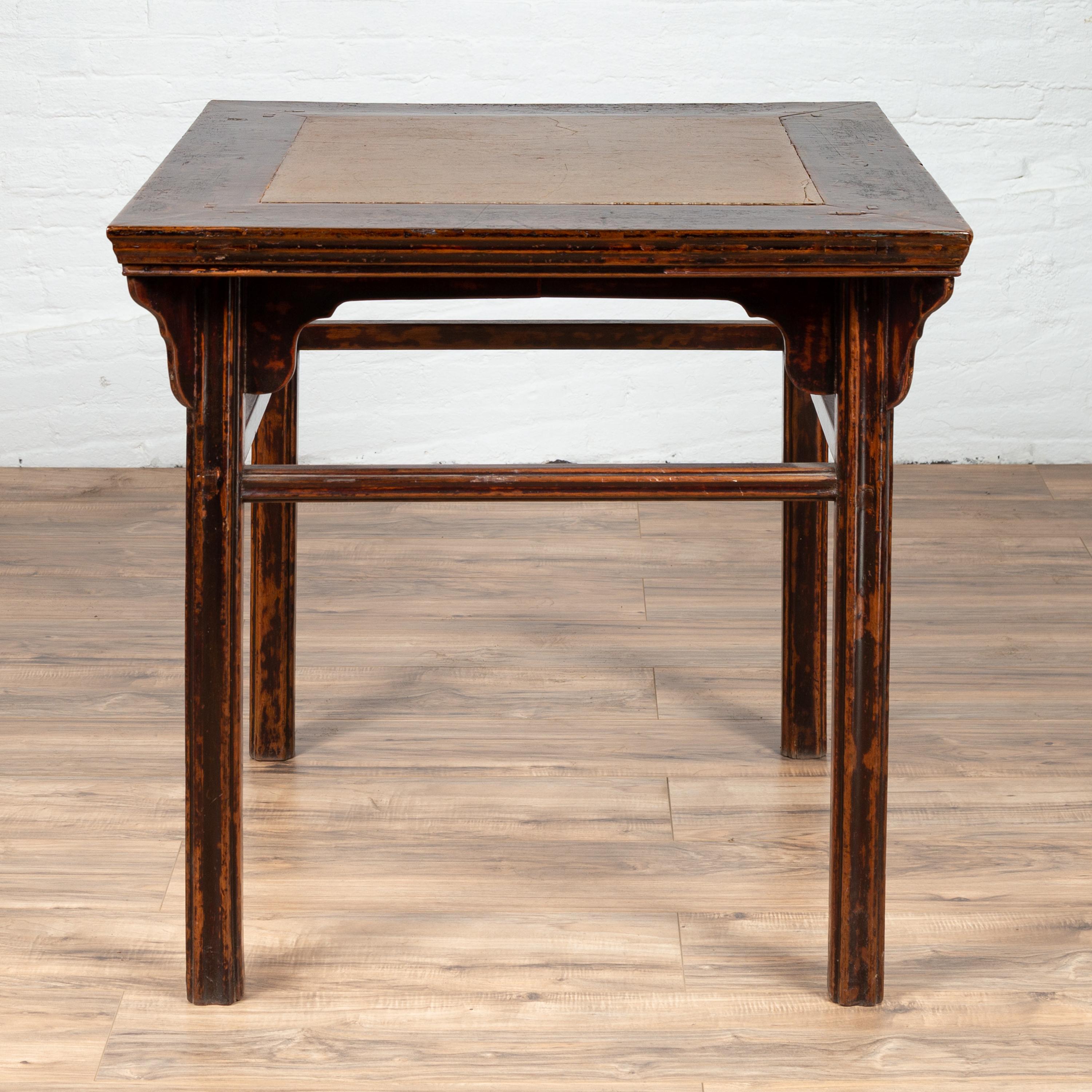 A Chinese 19th century elmwood center hall table with Ming dynasty 15th or 16th century courtyard stone inset. Born in China during the 19th century, this elegant center table features a square top, adorned with a Ming dynasty courtyard stone inset