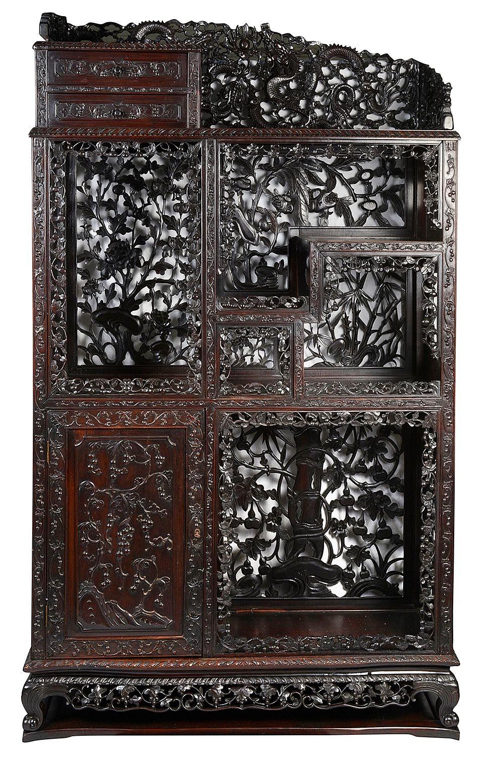 A very good quality set of 19th Century Chinese hardwood shelves with open shelves, drawers and cupboards. Having wonderful quality hand carved and pierced folate decoration and mythical dragons to the top. Raised on carved scrolling feet.

Batch 75