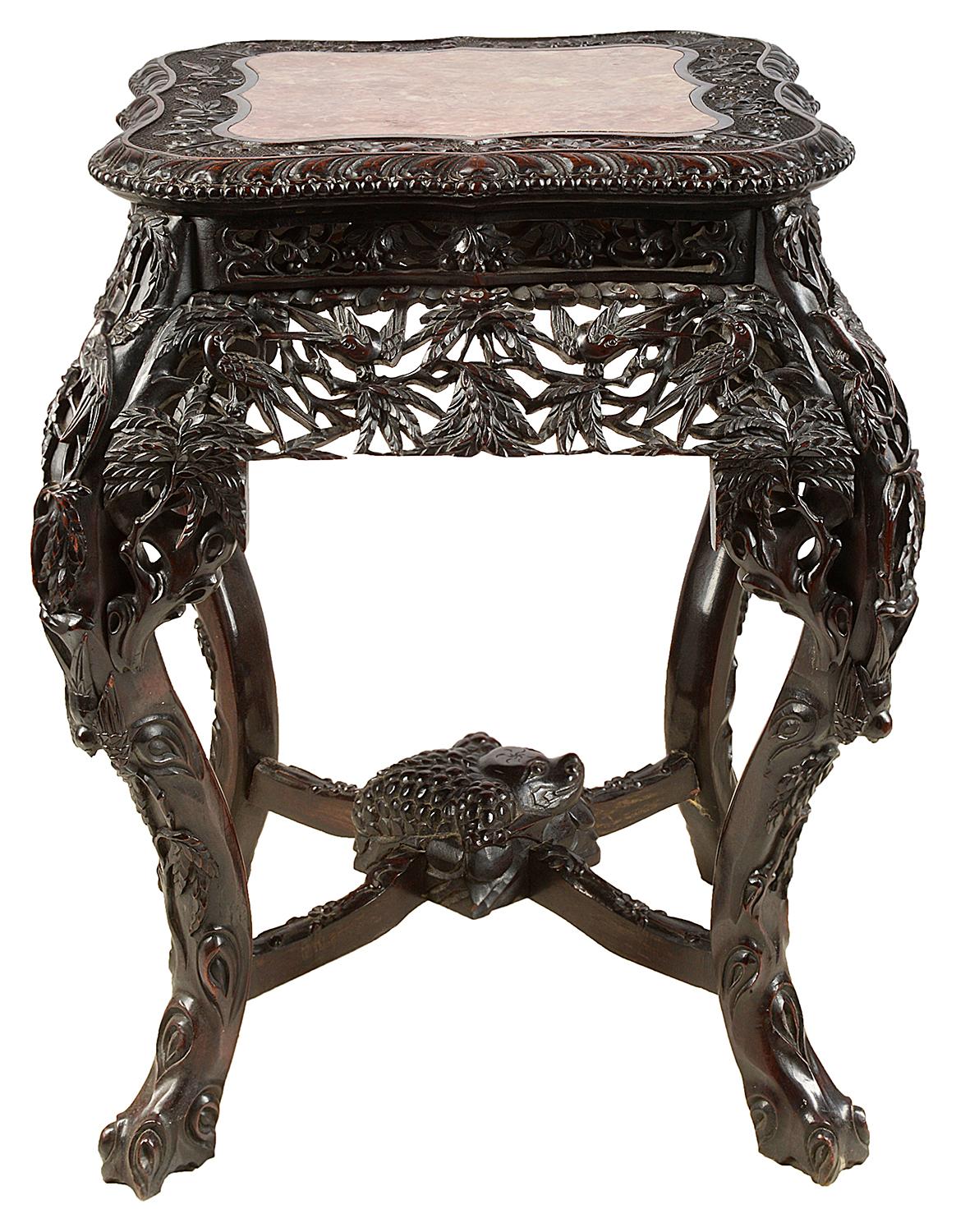 A very good quality 19th century Chinese hardwood stand, having inset rouge marble top, wonderful hand carved palm leaves and exotic bird decoration, raised on tree like cabriole legs, united by an X-stretcher with a carved mythical creature to the
