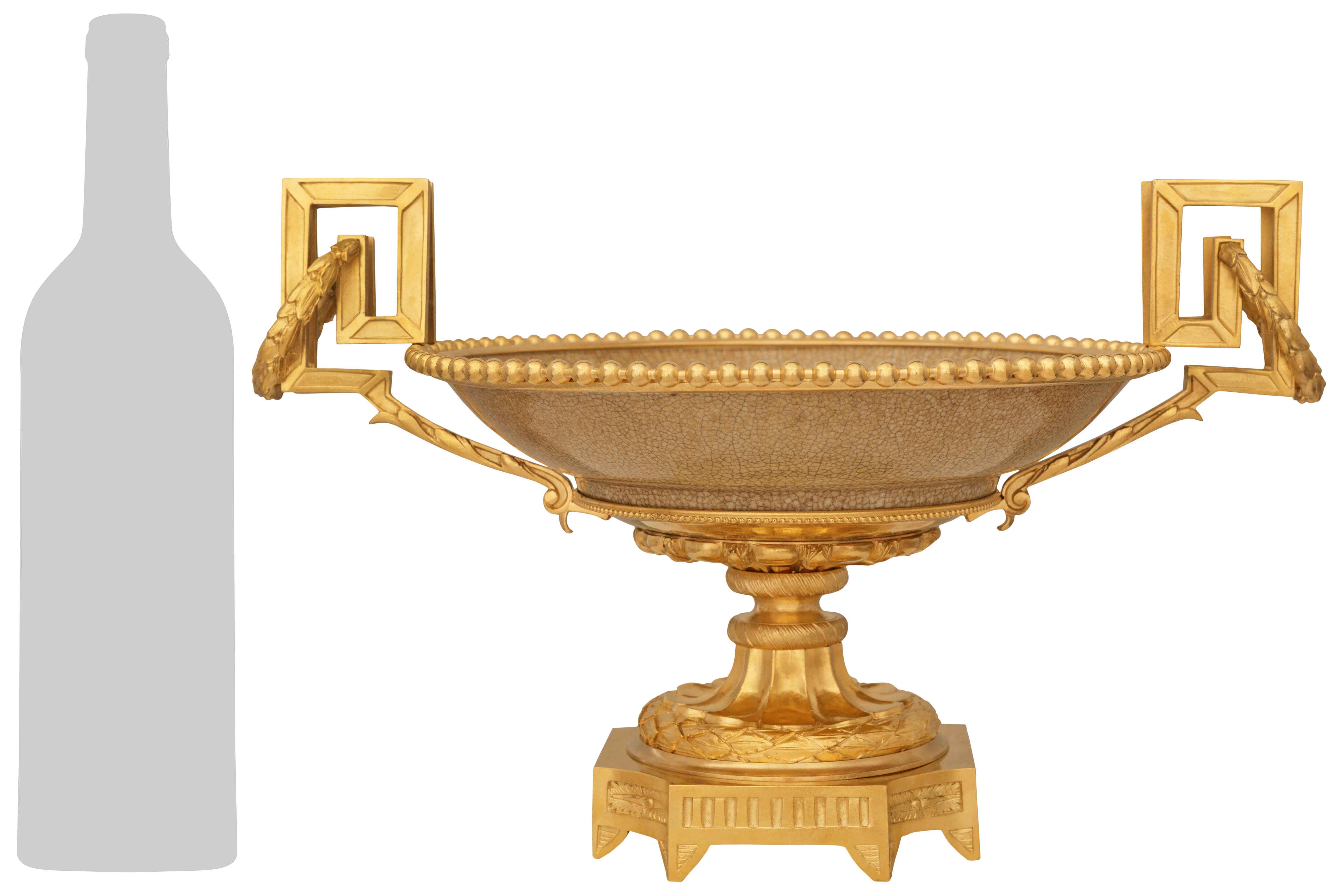 Magnifique centre de table en porcelaine chinoise du XIXe siècle et en bronze doré de style Louis XVI. Cette pièce maîtresse des plus élégantes est surélevée par huit pieds pointus sous une base carrée en bronze doré dont les coins concaves sont
