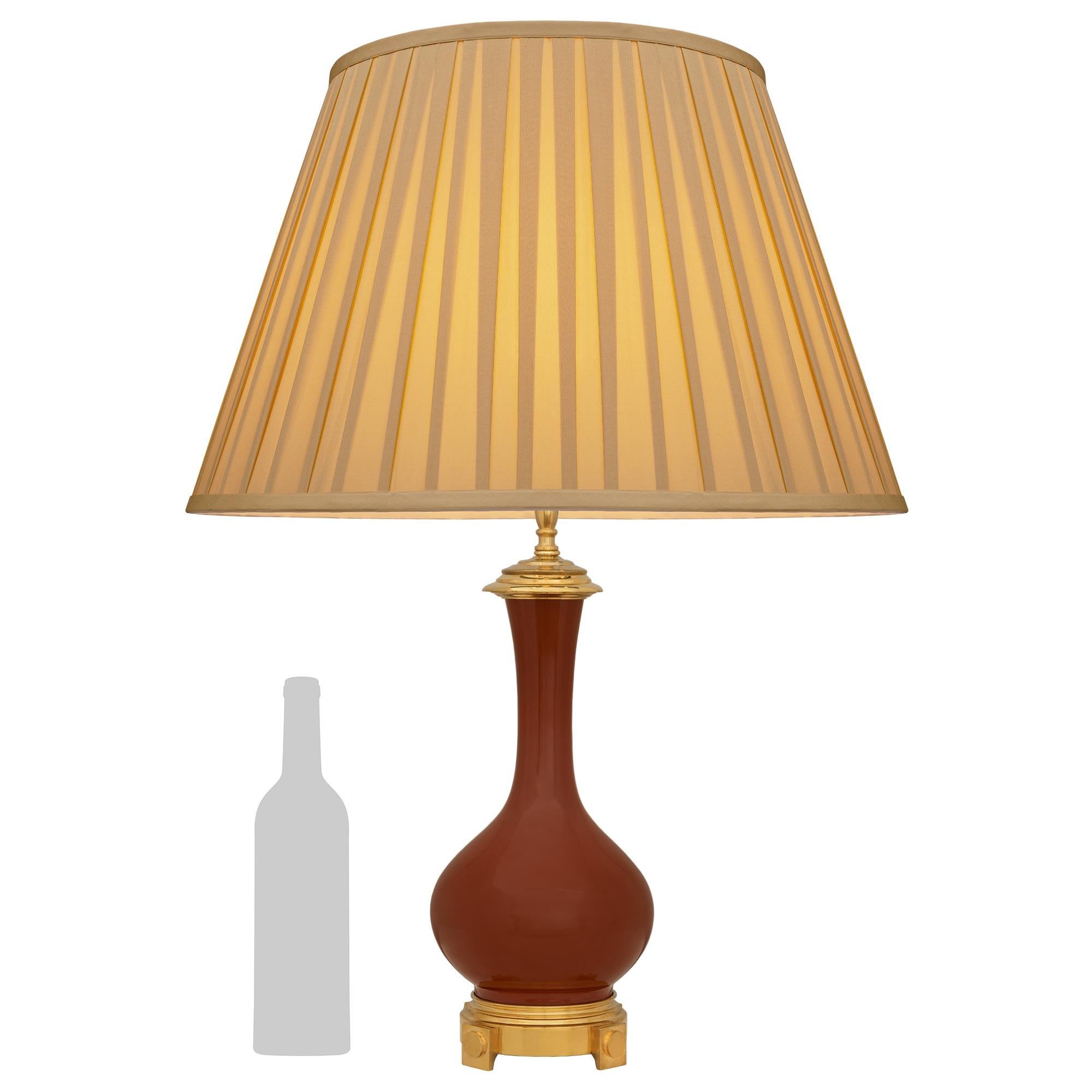 Très belle lampe chinoise du 19ème siècle en porcelaine et en bronze doré de style Louis XVI. Cette remarquable urne en porcelaine de couleur sang-de-bœuf montée en lampe repose sur une base circulaire en bronze doré de style Louis XVI du XIXe