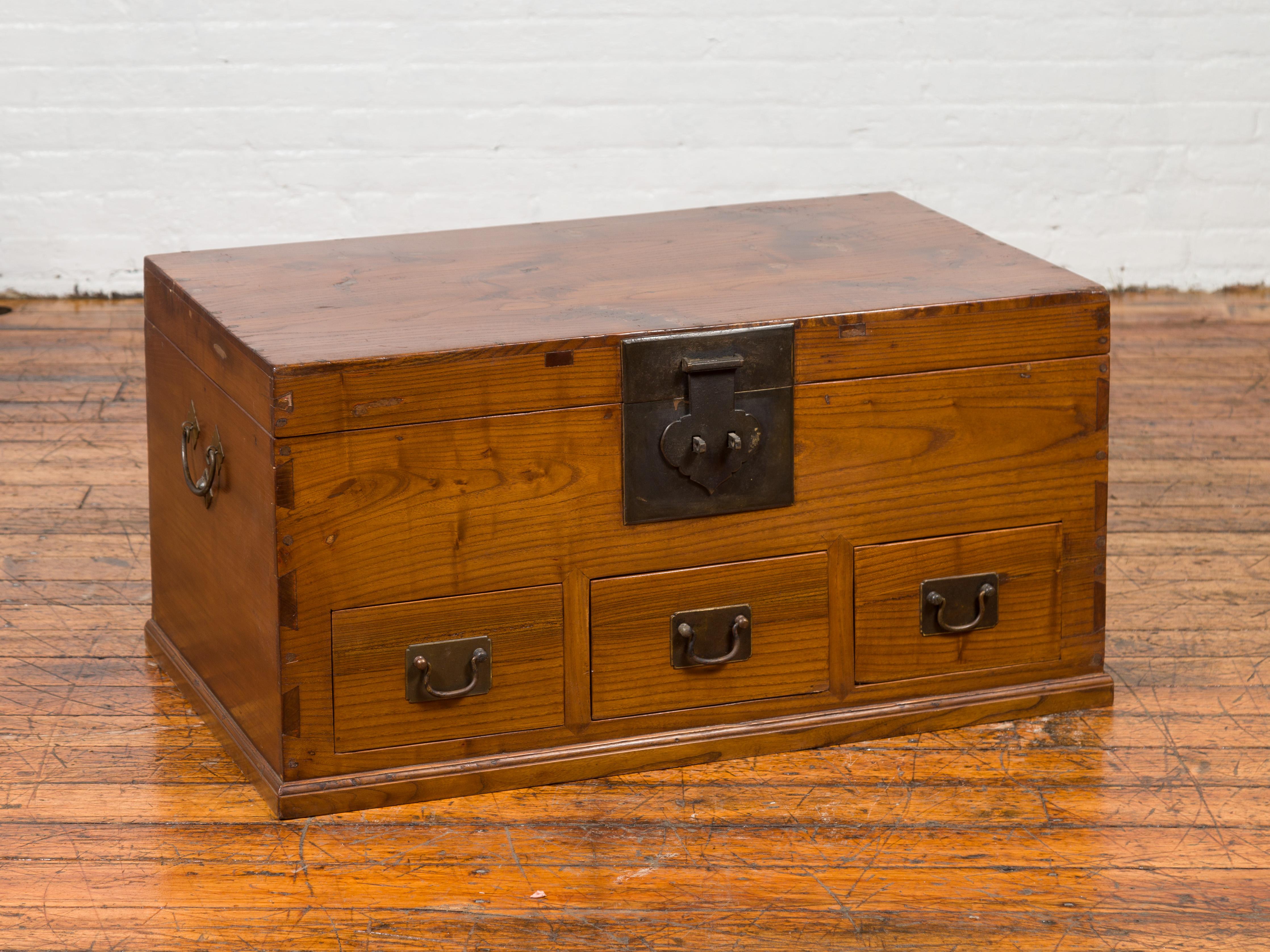 A Chinese Qing Dynasty antique blanket chest from the 19th century, with three drawers, dovetailed construction and distressed patina. Crafted in China during the 19th century, this blanket chest features a rectangular lid that opens thanks to a