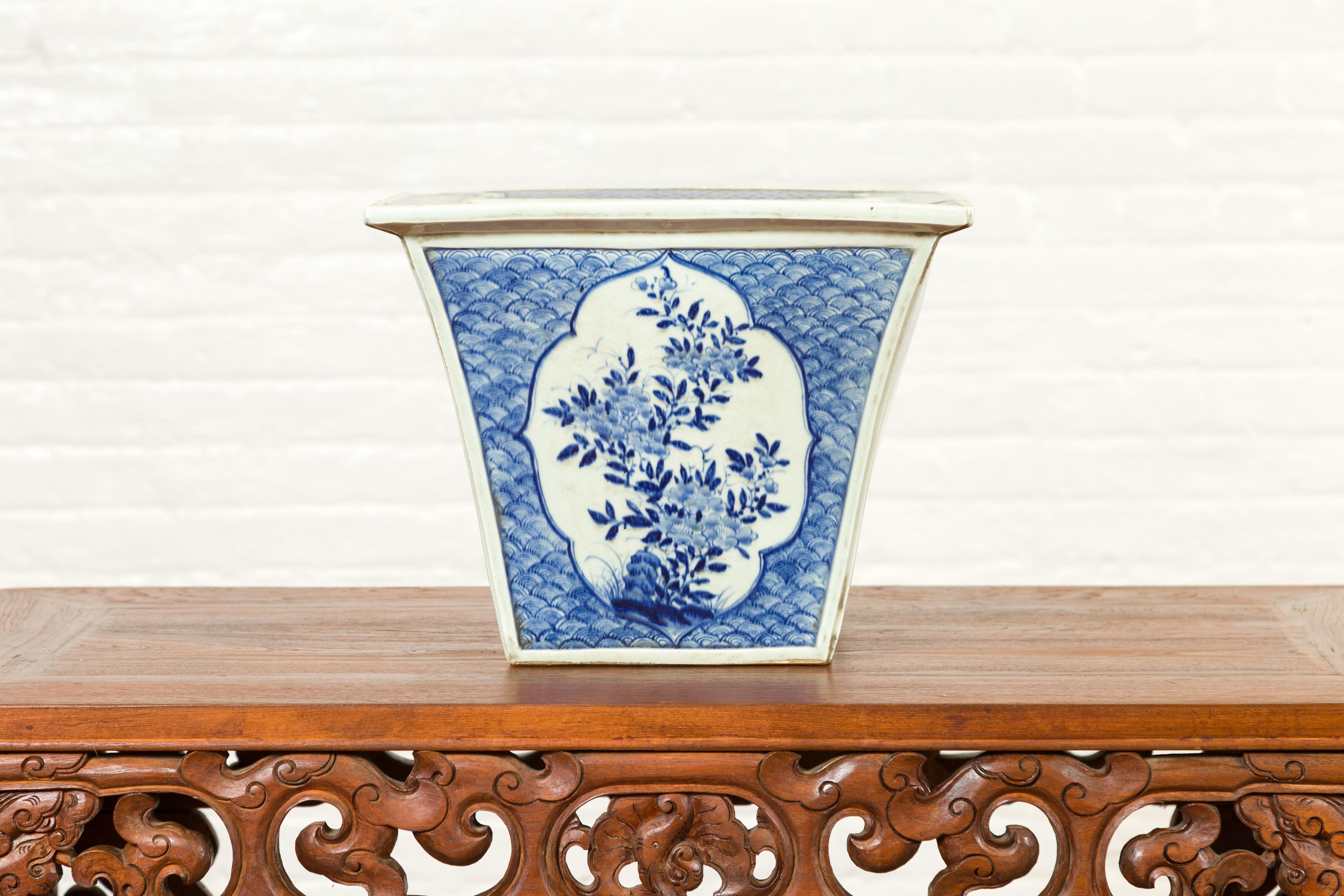 A Chinese Qing Dynasty period blue and white planter from the 19th century, with floral décor and underglaze design. Created in China during the Qing Dynasty, this planter features a flaring silhouette, beautifully adorned with vertical scrolling