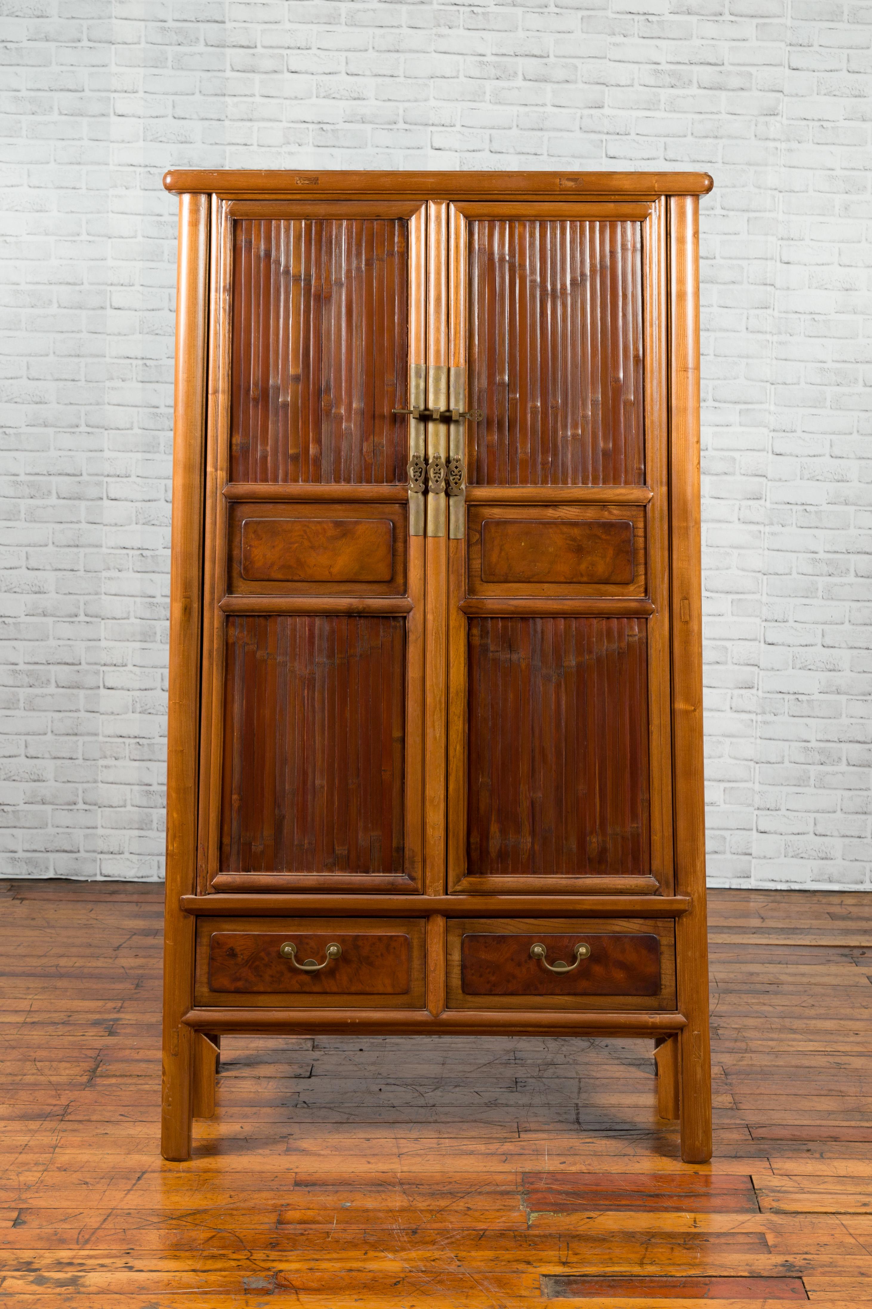 A Chinese Qing dynasty period elm cabinet from the 19th century with bamboo slats, tapered design and lower drawers. Created in China during the Qing dynasty, this elm noodle cabinet features a tapering silhouette perfectly adorned with bamboo slats