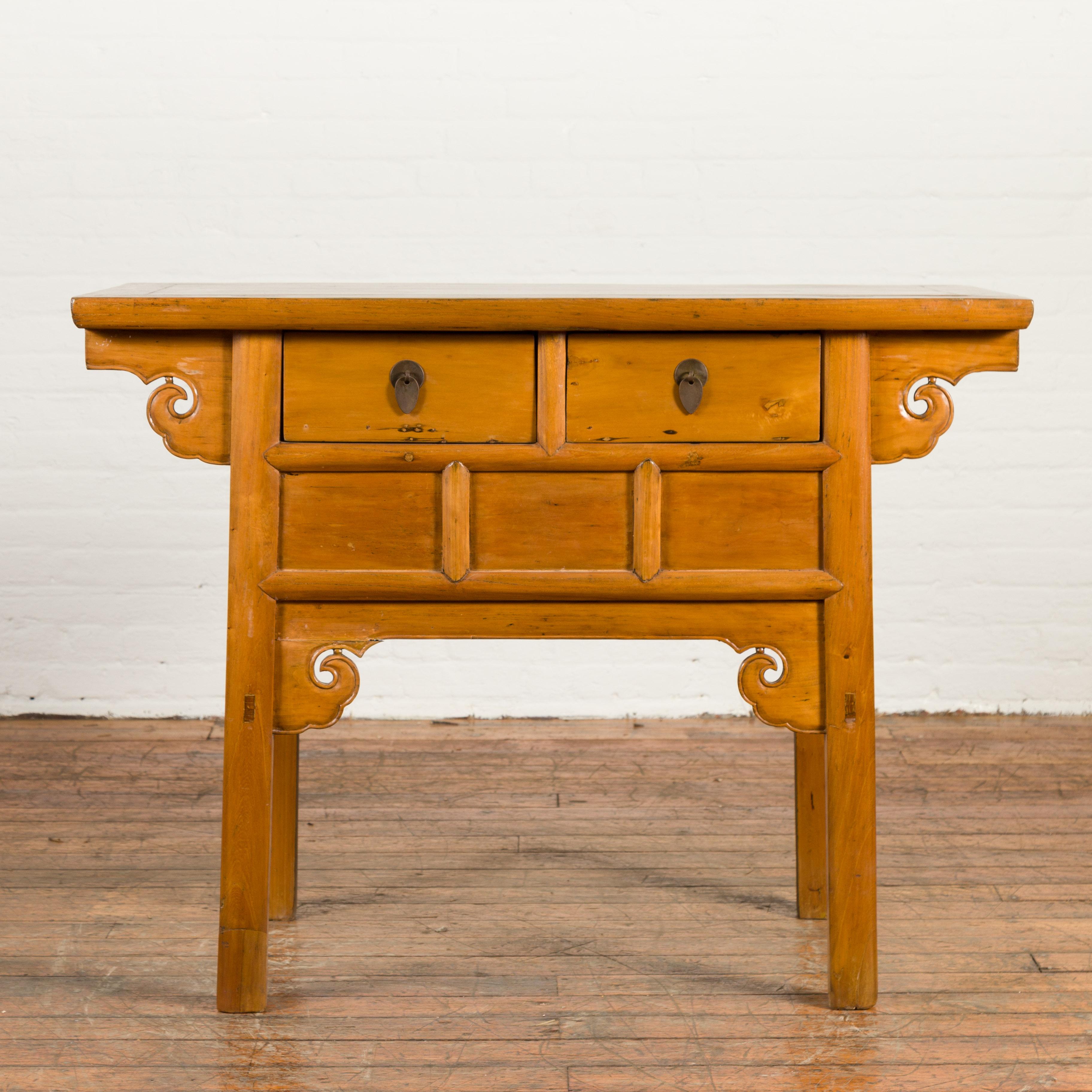 A Chinese Qing Dynasty period elm coffer table from the 19th century, with carved spandrels and drawers. Created in China during the Qing Dynasty, this elm coffer table features a rectangular top with central board, sitting above a perfectly