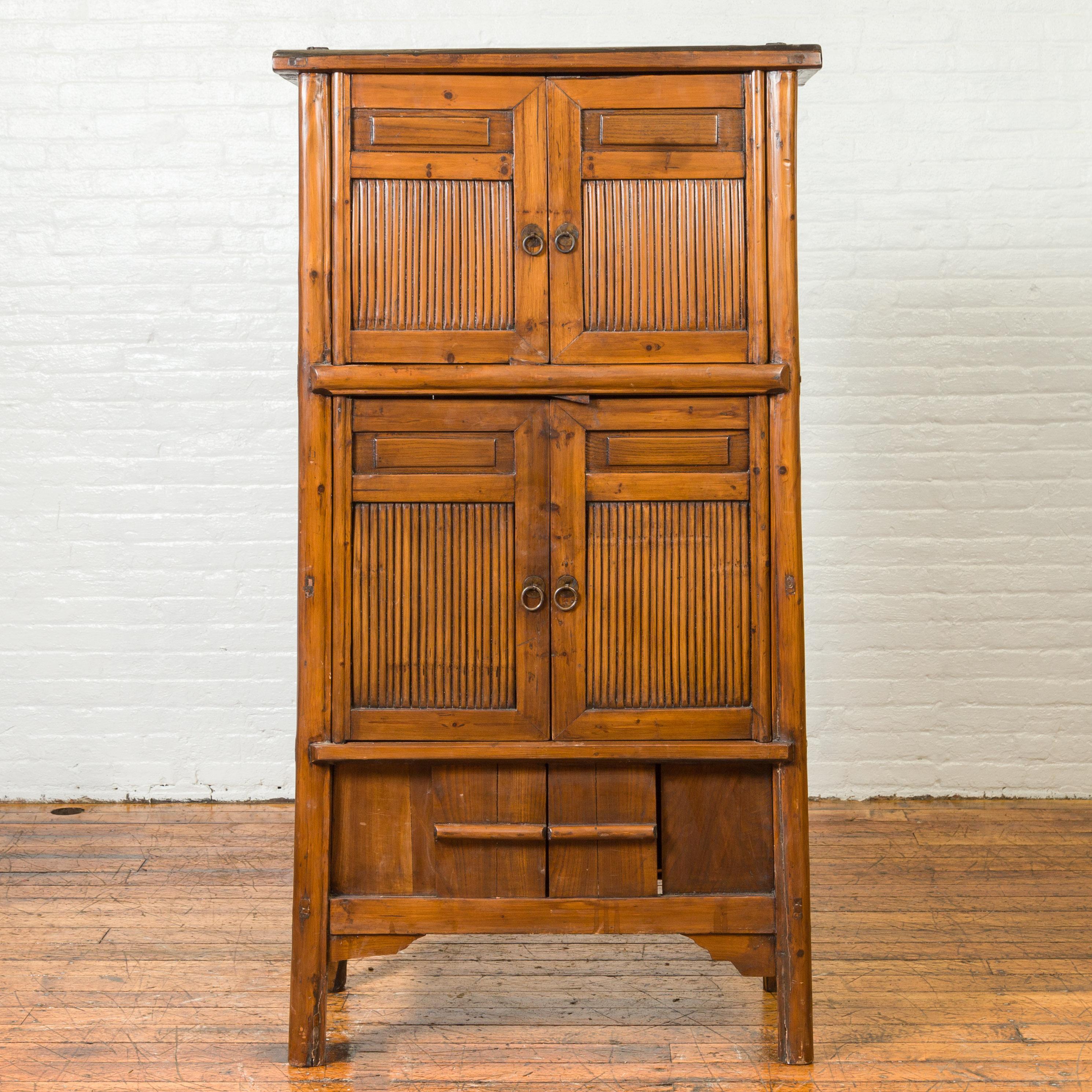 An antique Chinese Qing Dynasty period kitchen cabinet from the 19th century with bamboo, two pairs of double doors and sliding panels. Created in China during the Qing Dynasty, this bamboo kitchen cabinet features a flaring silhouette showcasing