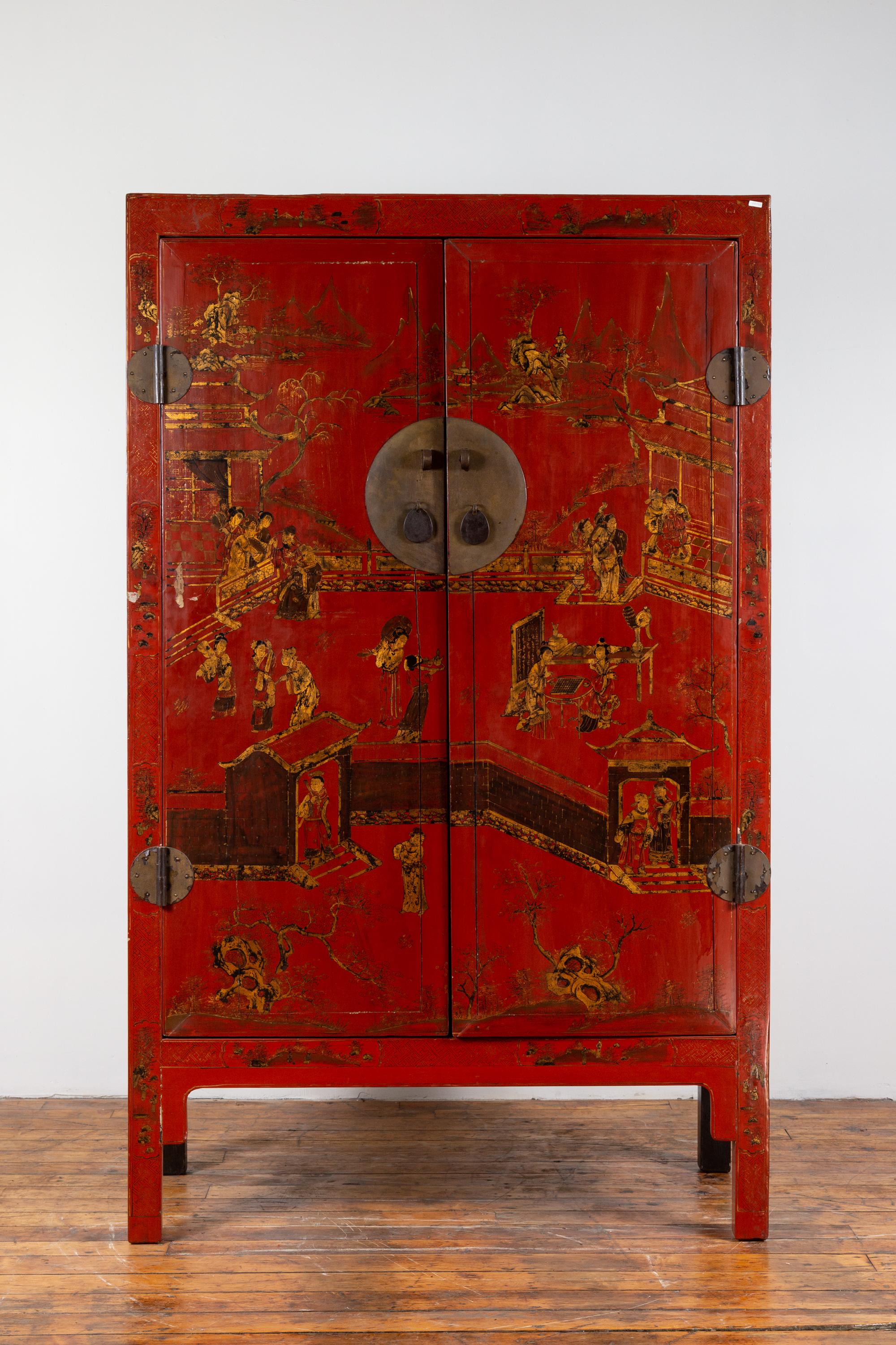 A Chinese Qing dynasty red lacquered cabinet from the 19th century, with gilt chinoiserie décor and hidden drawers. Born in China in the last years of the Qing dynasty, this wedding cabinet features two doors, beautifully adorned with gilt court