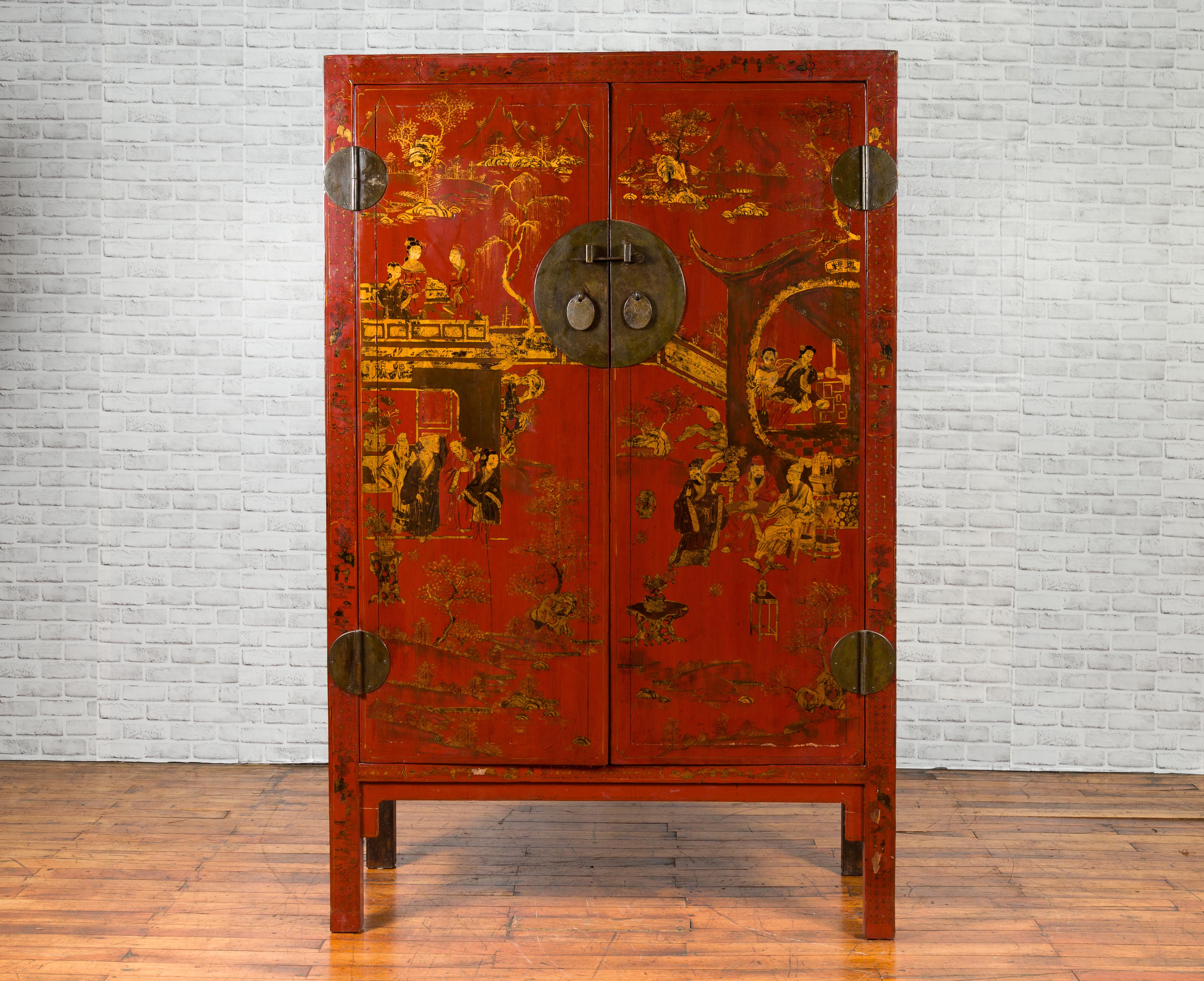 A Chinese Qing dynasty period red lacquered cabinet from the 19th century, with hand painted gilt chinoiserie decor. Created in China during the Qing dynasty, this cabinet is varnished with a red lacquer. The façade showcases two doors adorned with