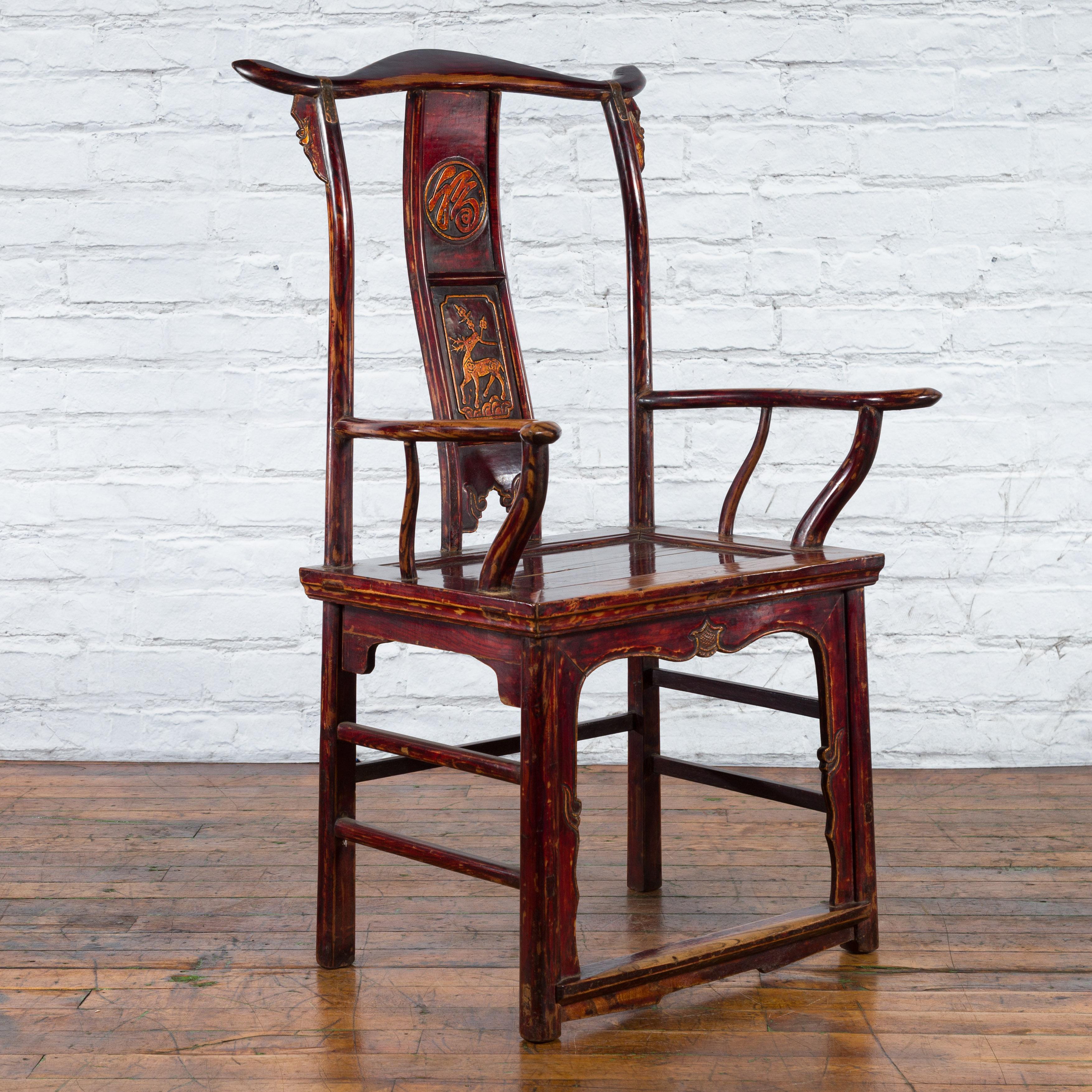A Chinese Qing Dynasty period yoke back armchair from the 19th century with original finish and carved splat. Created in China during the Qing Dynasty, this armchair features a rectangular wooden seat with recessed panel, supporting two delicate