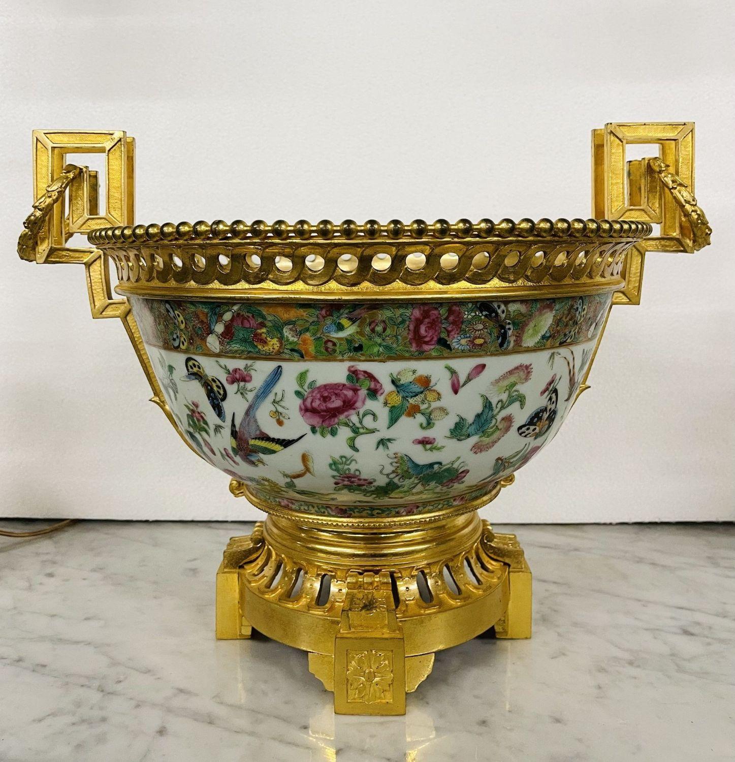 Chinese gilt-bronze mounted rose medallion center piece bowl, 19th century. A stunning Centerpiece of Chinese deisgn having a circular tapering form, with pierced Greek key designed rim, flanked by similar scroll handles, raised on a socle and
