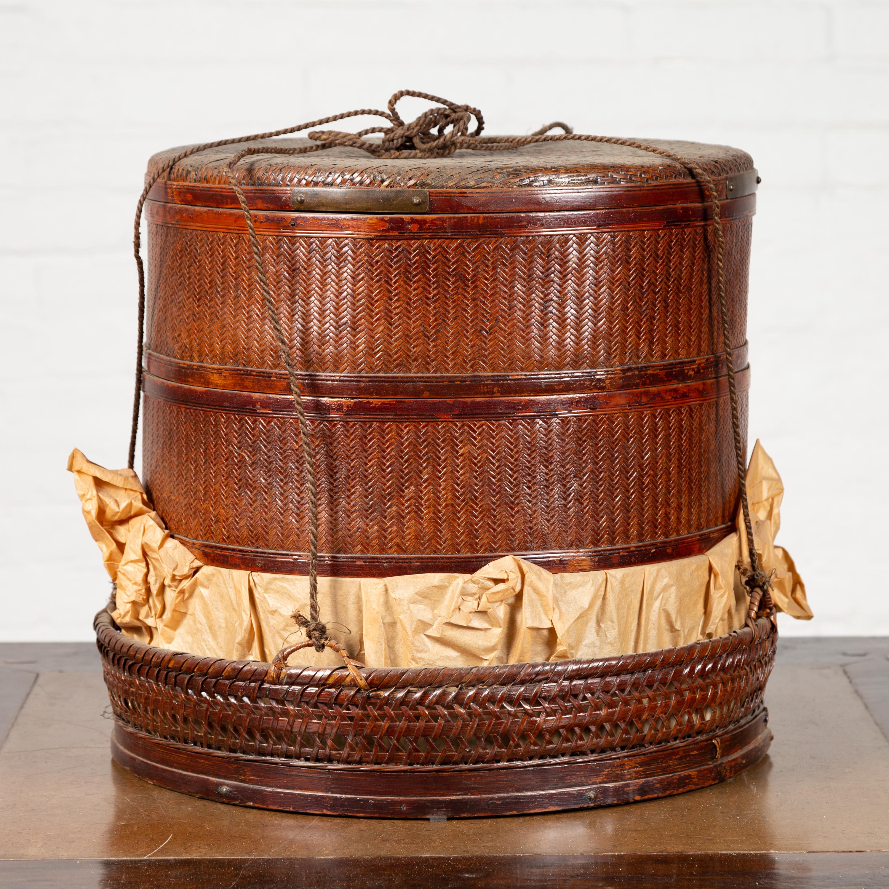 A Chinese antique tiered food basket from the 19th century, with stacking compartments, paper and rope ties. Born in China during the 19th century, this tiered food basket charms our eyes with its rustic appearance and convenient features. Made of