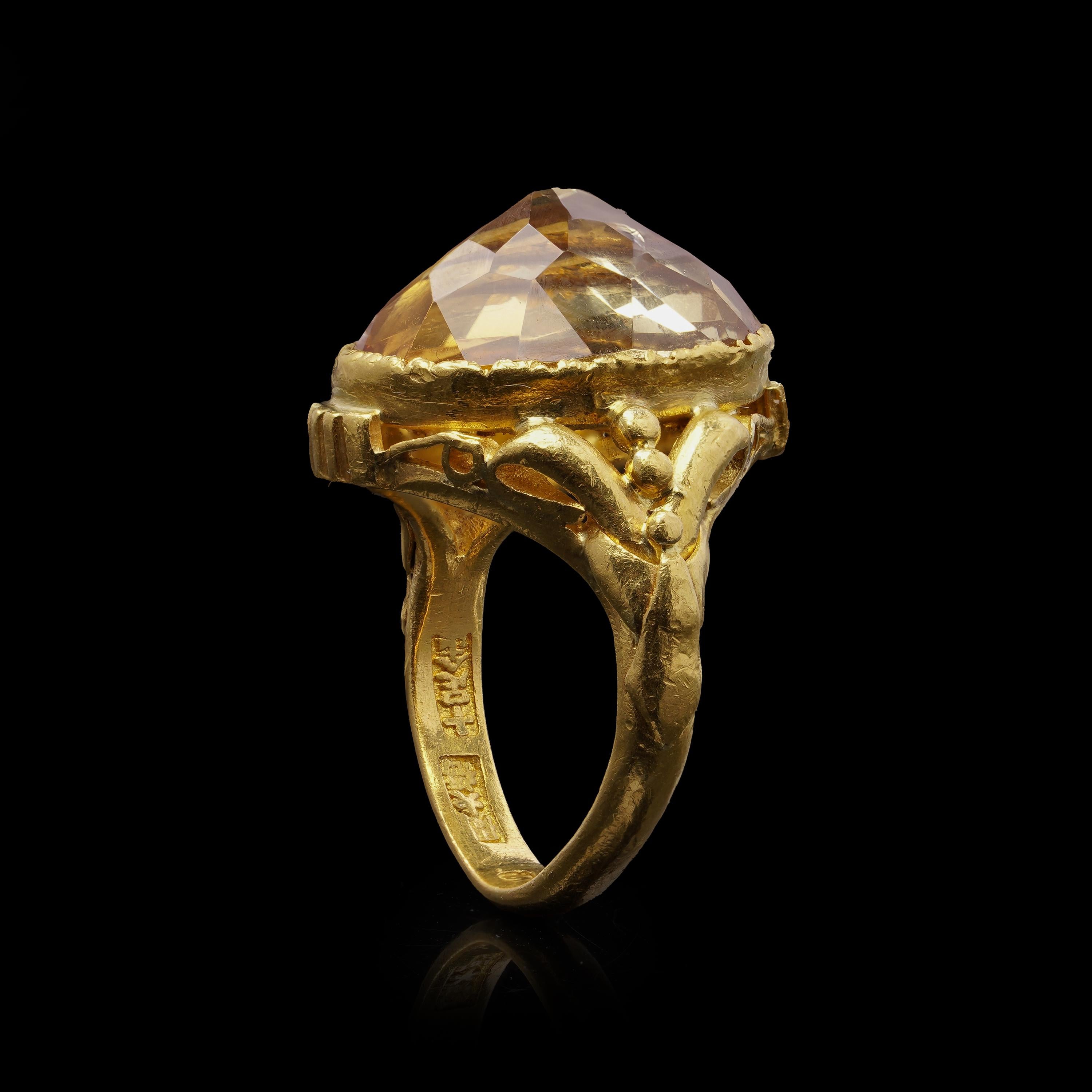 A bold and elegant ring crafted in richly hued 23kt yellow gold, featuring a large oval-faceted citrine in a high-polished bezel setting. The deep golden tones of the metal and the glowing 7.30 ct citrine create a luxurious statement piece that