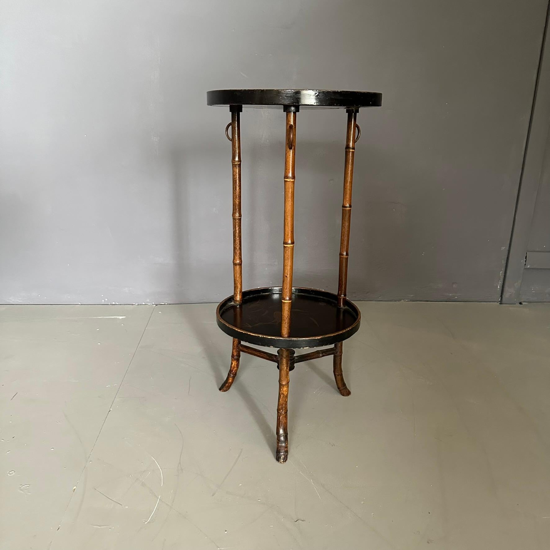 Chinese coffee table/holder, dating back to the early twentieth century.
The coffee table has a three-legged bamboo structure with round black-plated wooden tops with naturalistic designs.
The table tops represent naturalistic scenes and landscapes.