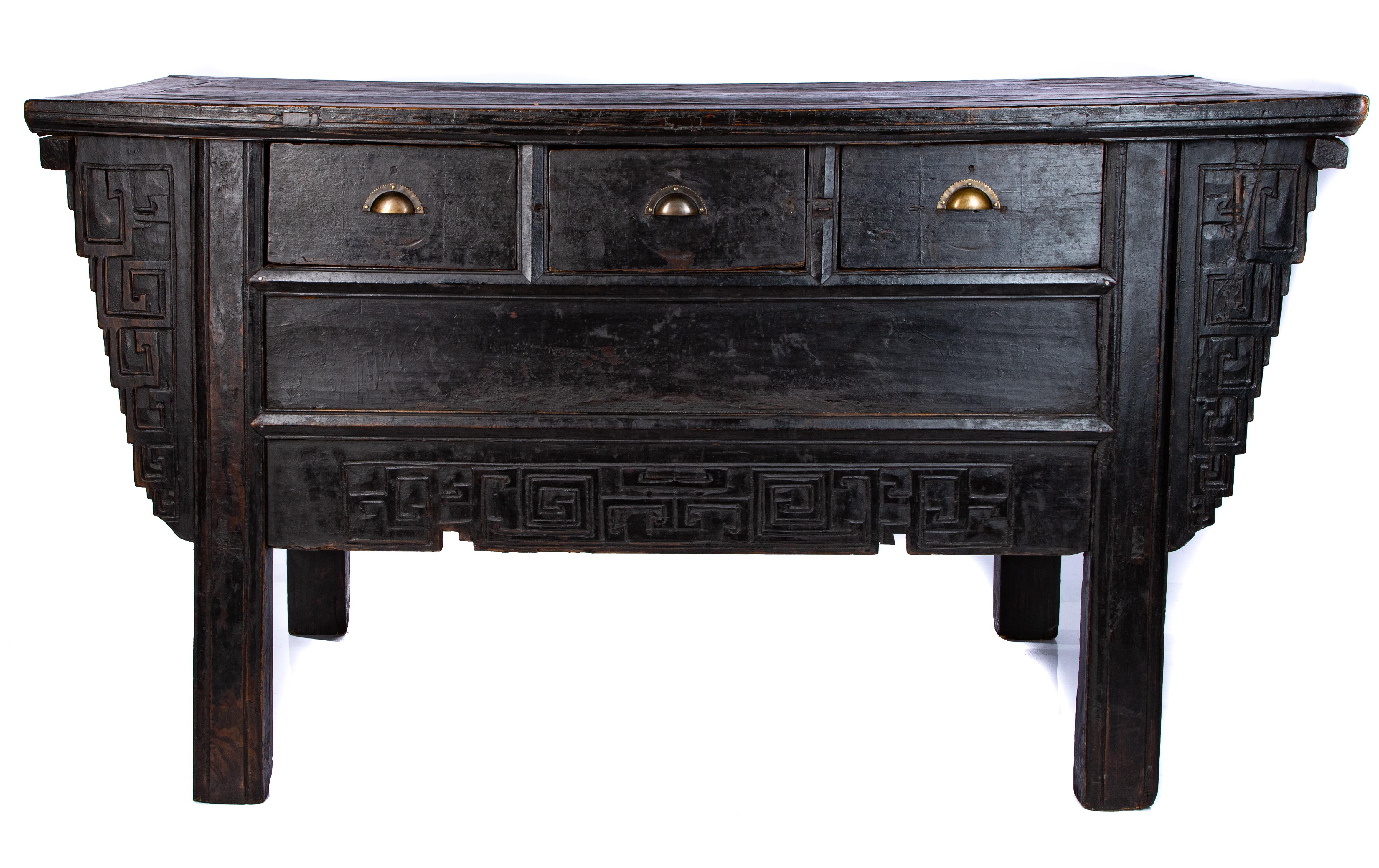 Offering this unmatchable Chinese altar table from the early 19th century. Starting on square legs rising up to gorgeous hand carved panels that flank either side, and a stretcher across the front in a geometric Chinese motif. Has three drawers with