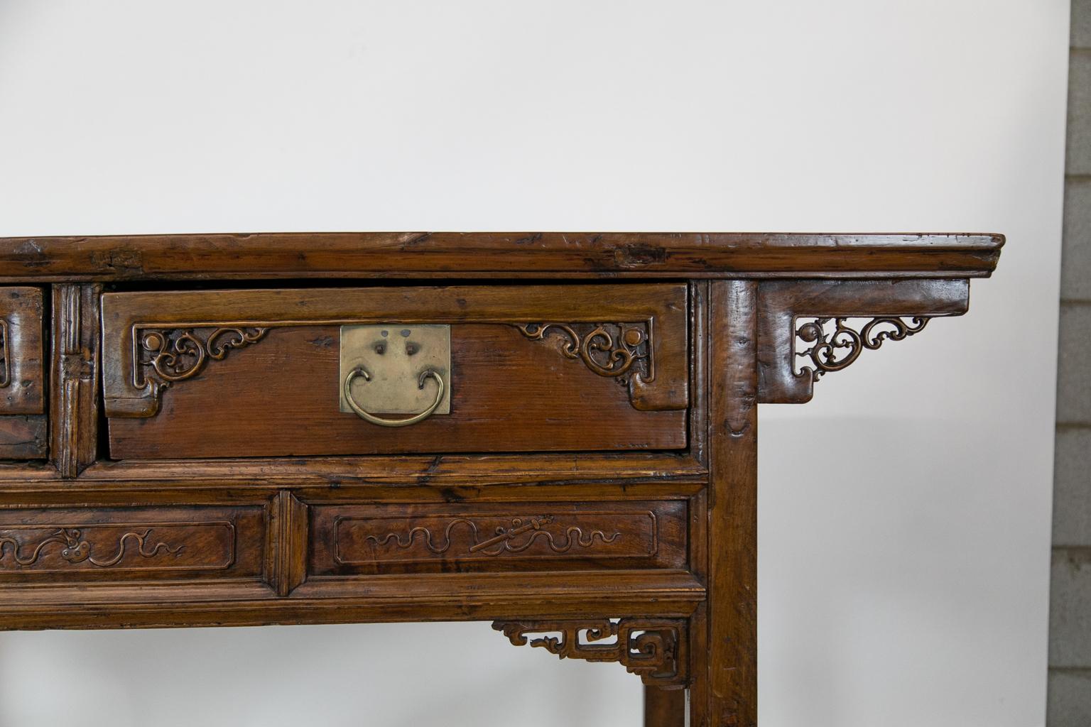 This altar table is made of Asian fruitwood and has carved Asian panels in the drawers and supporting panels. The panels below the drawers conceal hidden compartments that can only be accessed by removing the drawers.