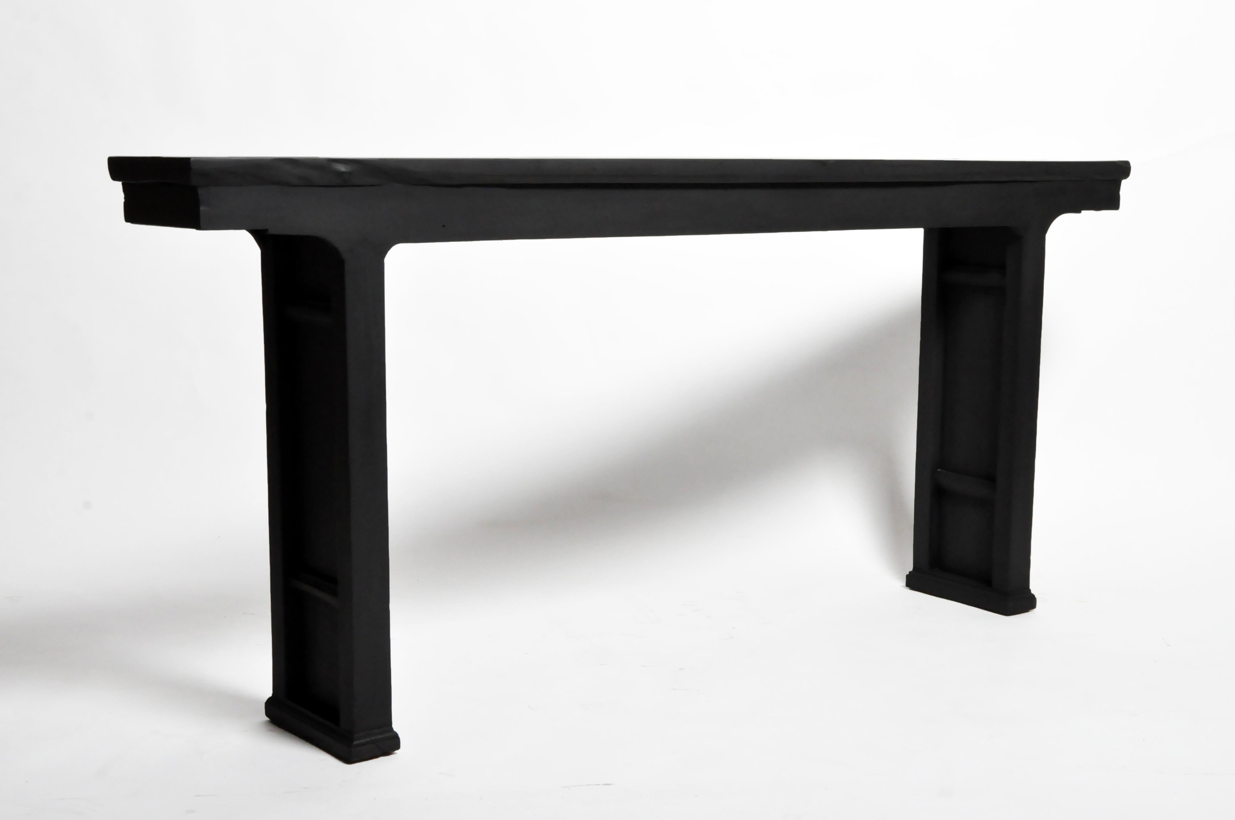 This slim and elegant Northern Chinese table is made from elm and peach woods and dates to the 19th century. It has been extensively refinished as its original finish had already been altered. The new finish is a multi-layered black paint with a