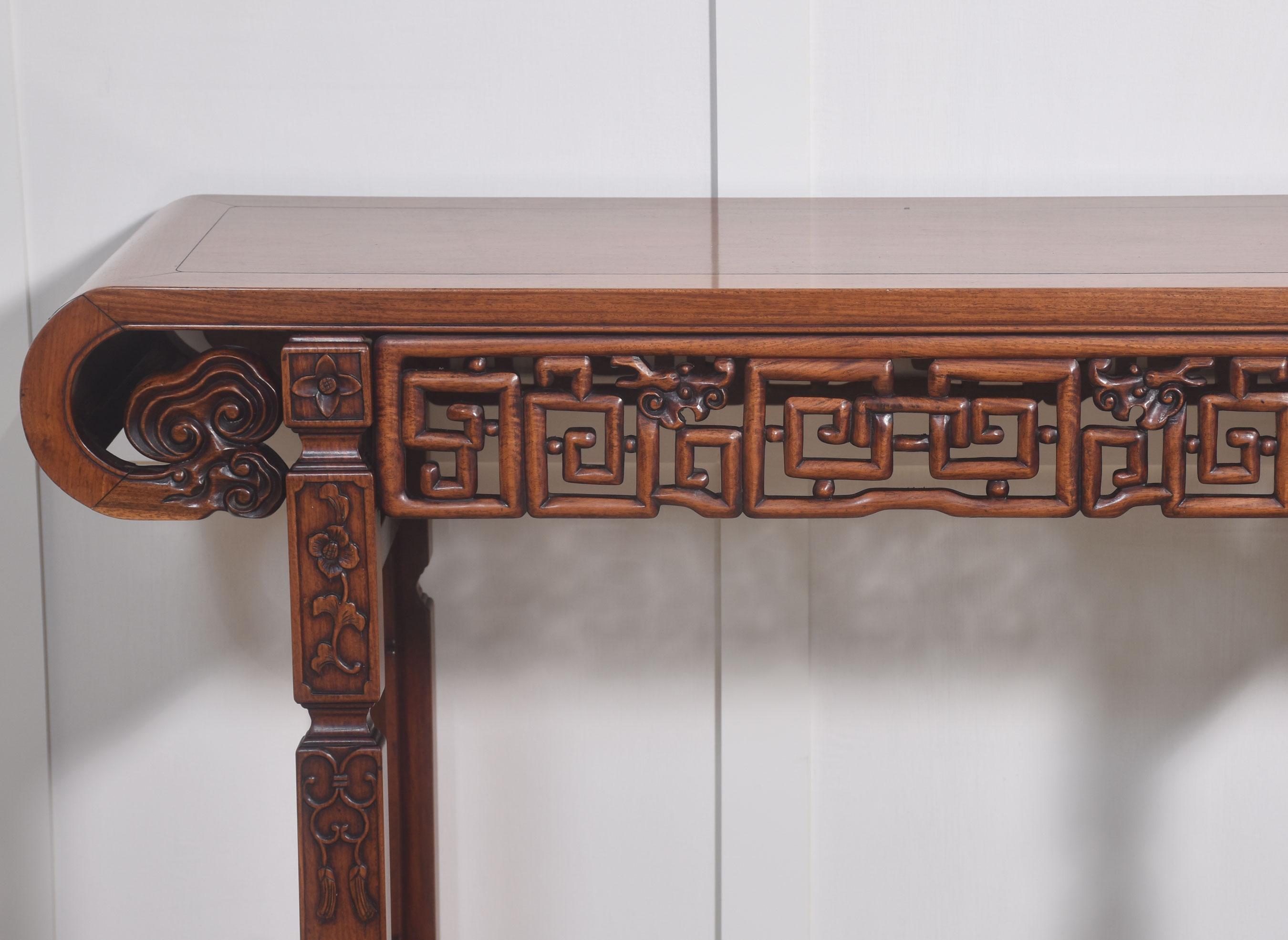 Chinese altar table the rectangular top with shaped ends. To the geometrically pierced frieze carved with dragons heads. All raised up on square section legs. With flowering stems and tassel and scrollwork, united by stretchers.
Dimensions
Height