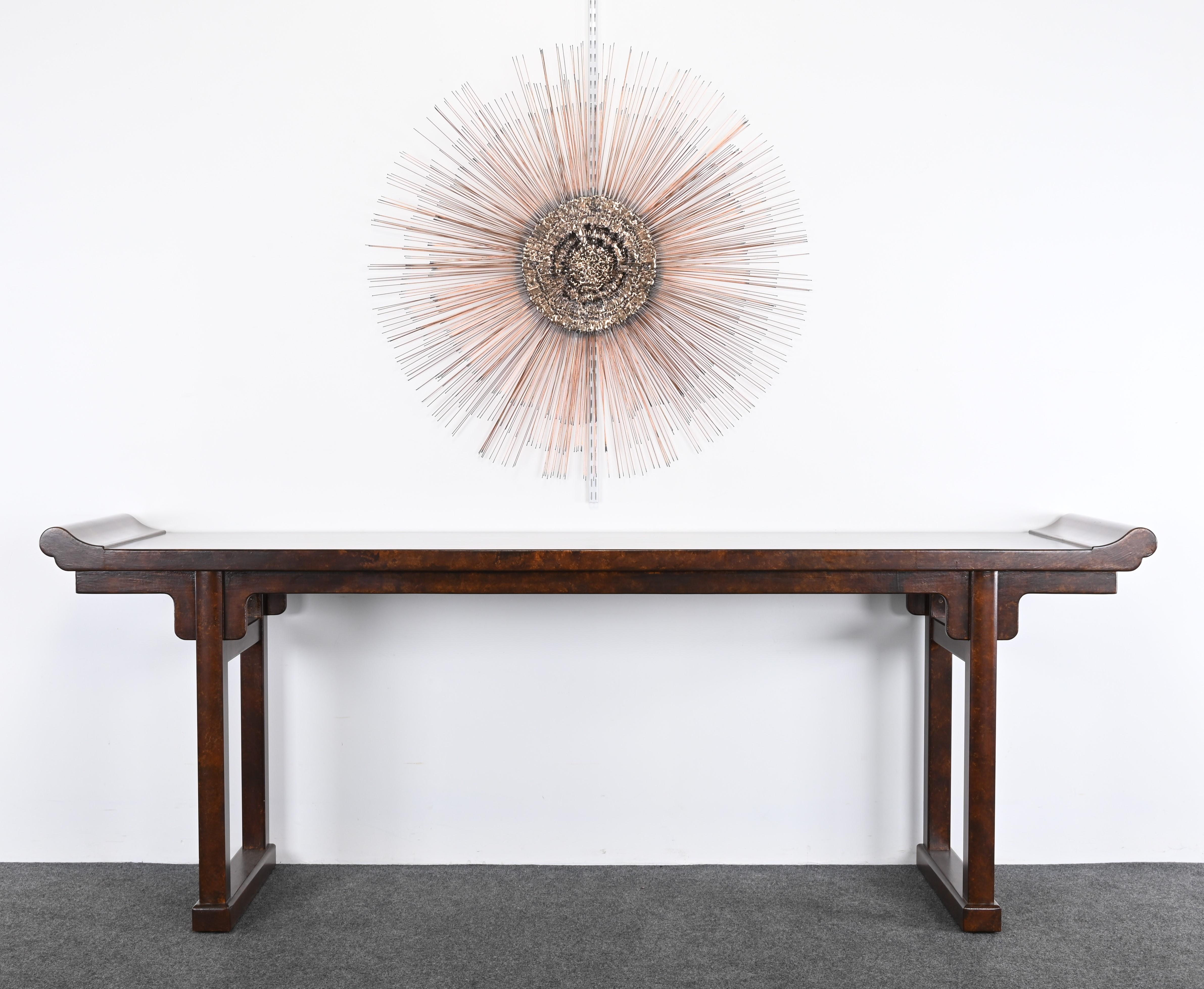 A stunning Chinese Altar Table in the manner of Baker Furniture Company, 20th Century. This Tortoise Shell Finished Console has great scale and is impressive in person. The altar table is a focal point for any interior, whether Traditional, Modern,