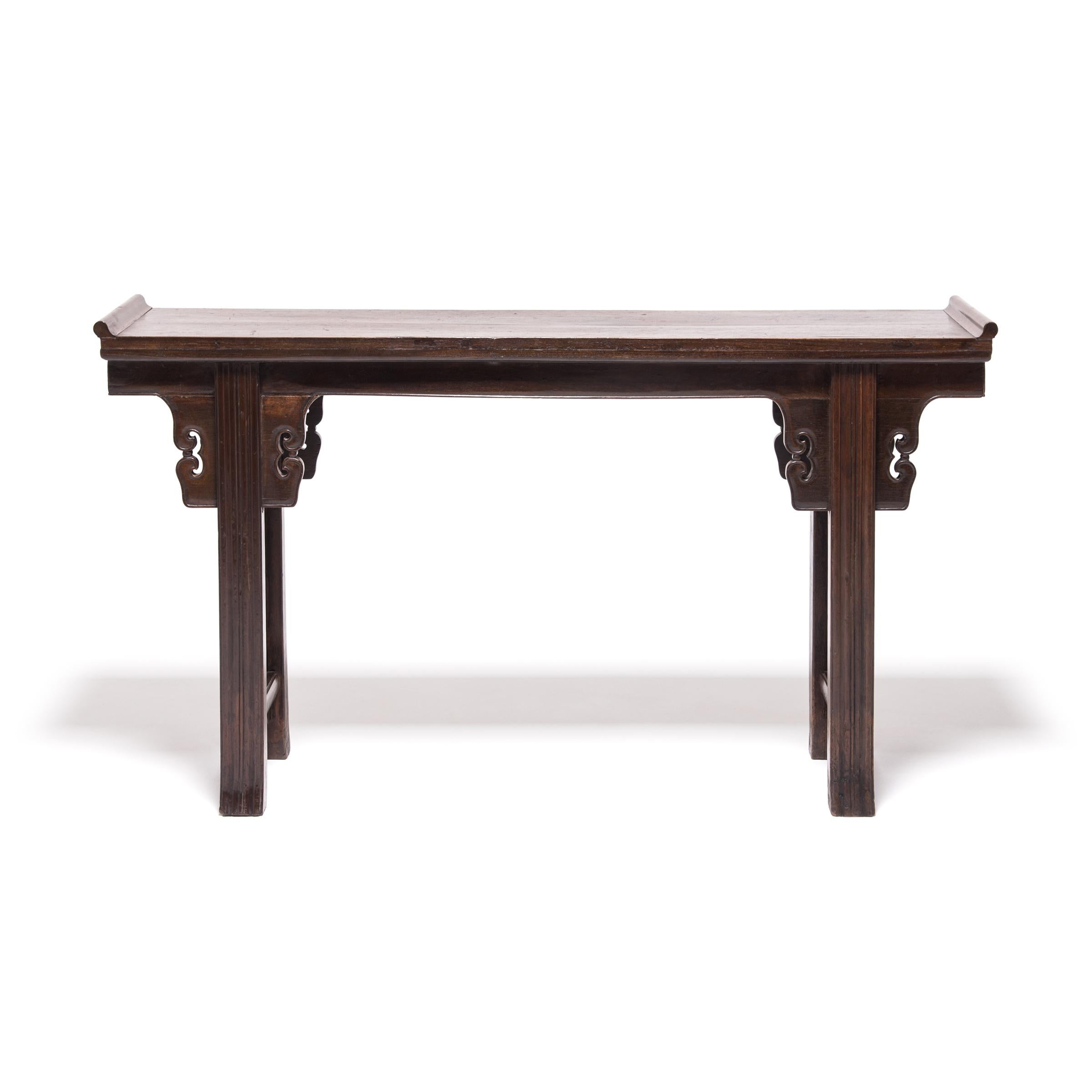 This elegant console table was made 150 years ago in China’s Shanxi province and likely served as a family’s altar where they paid respects to revered ancestors. The altar table is crafted of fine hardwood with carved spandrels, everted ends,