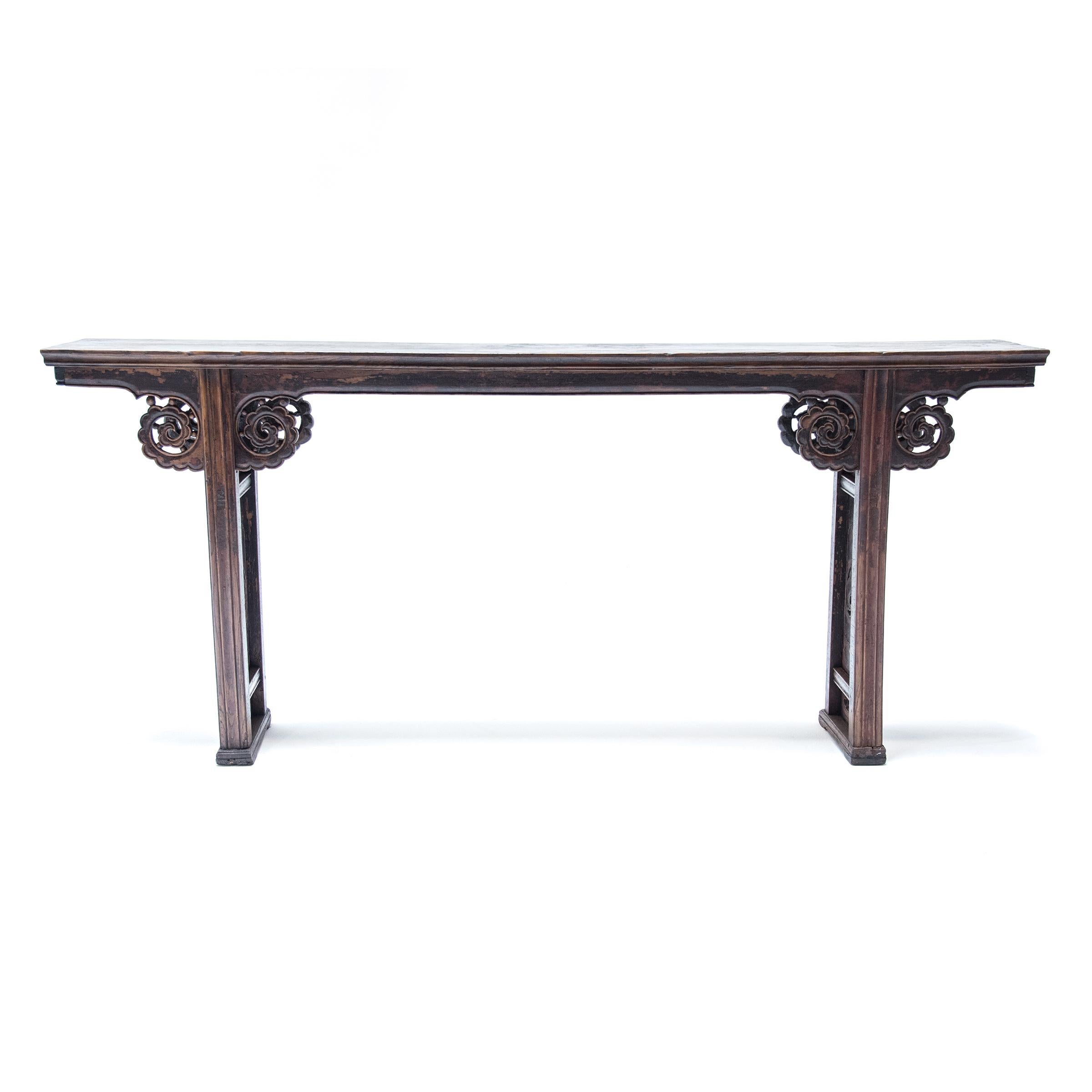 This gorgeous 19th-century console table was finely crafted from walnut by an artisan in China's Shanxi province. The narrow form would have been ideal for displaying painted scrolls or works of calligraphy. The plank-top surface is supported by