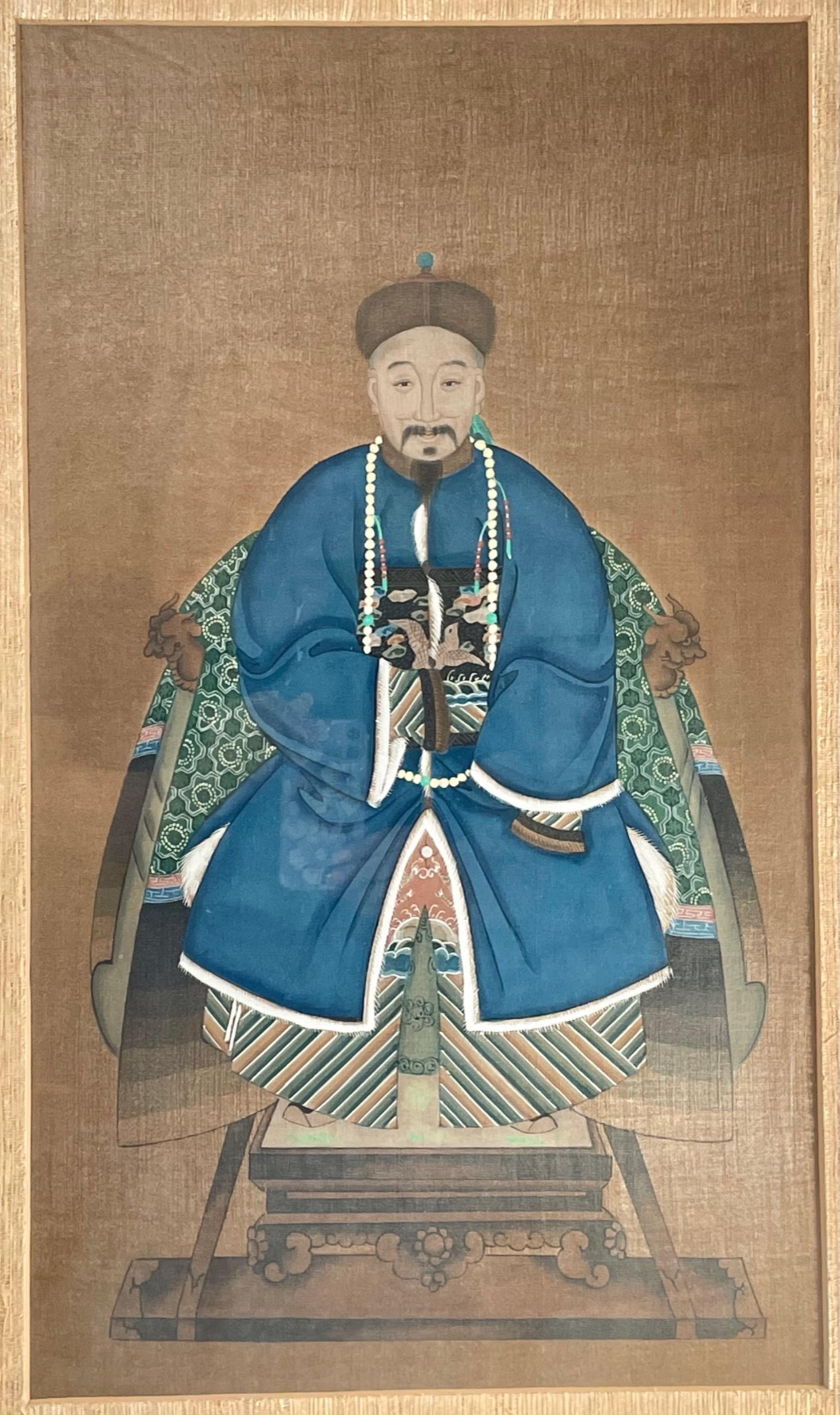 Chinese ancestor portrait of a Mandarin Dignitary. 

Antique tempera on paper painting of a Mandarin Dignitary wearing a blue court dress and seated on a throne chair. Based on the style of his formal robe, this man was probably an official of the