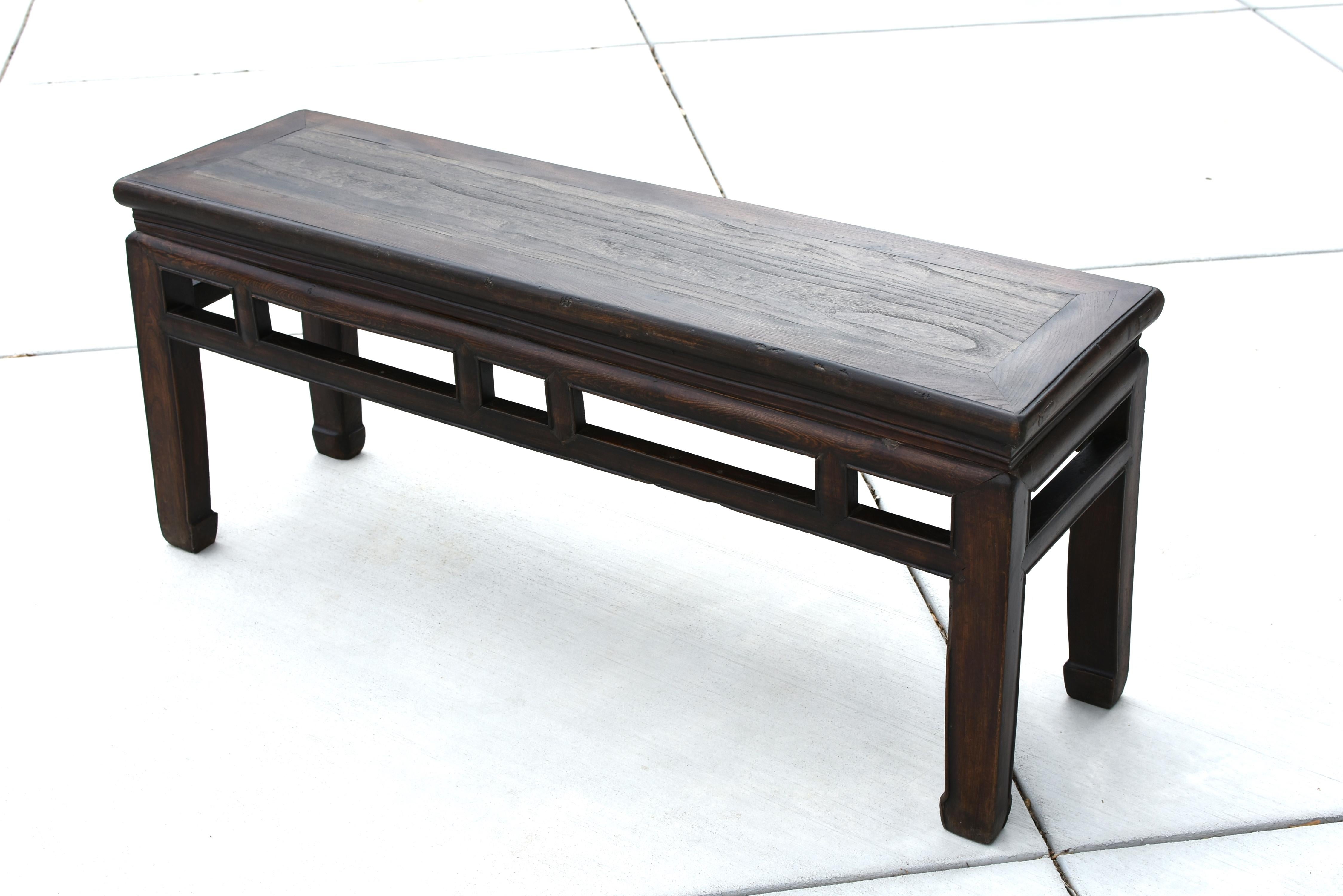 A beautiful, solid wood, 19th century antique bench from the region south of China's YangZi River. Solid single board inset in floating panel structure. Cinched waist. Geometric accent bars both decorative and functional in strengthening the