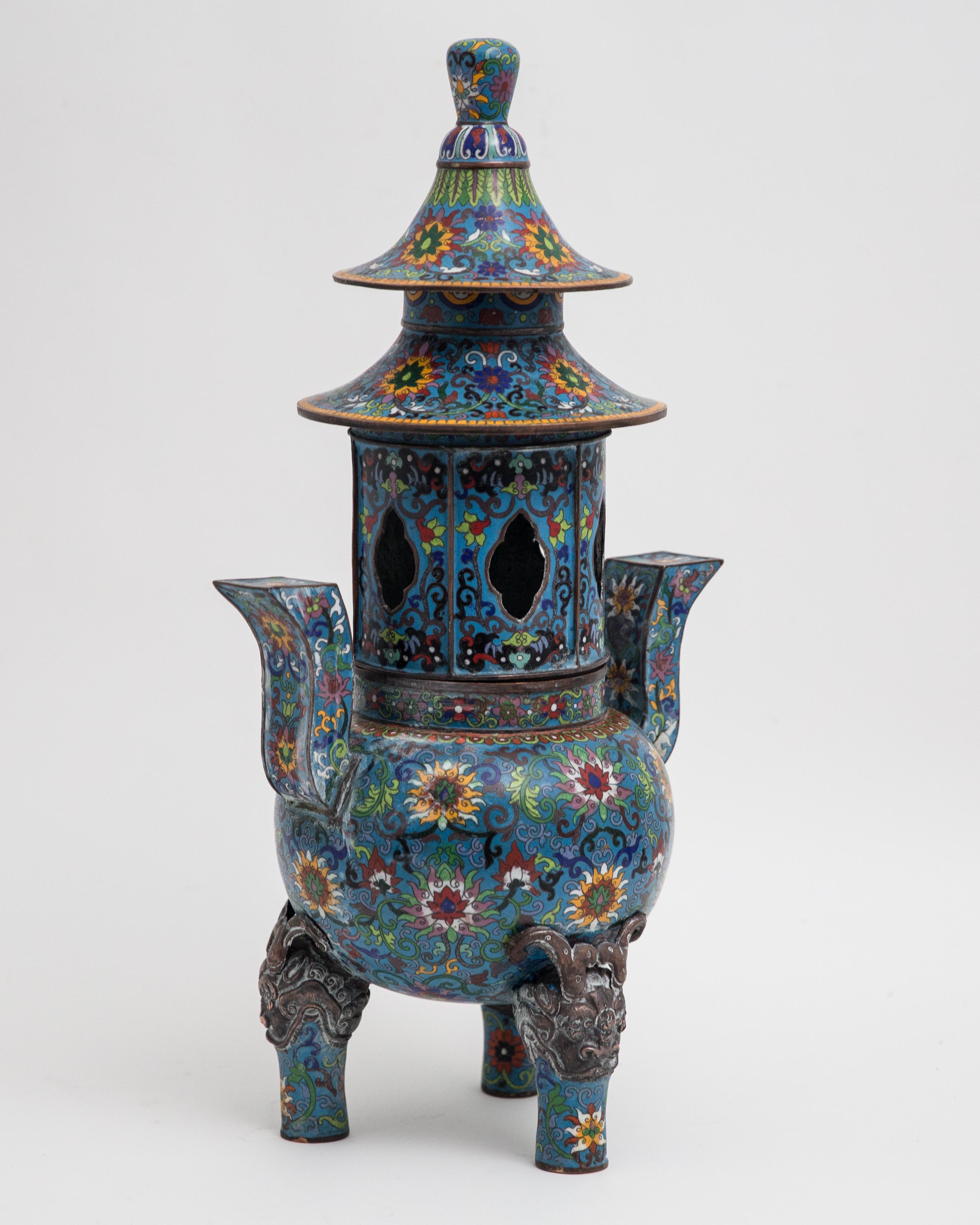 Offered is an impressive tall two part Chinese incense burner in the form of a pagoda. The cloisonné is in good condition. The pagoda stands approximately 26” in height. The pagoda top removes and the base is footed with demonic formed temple
