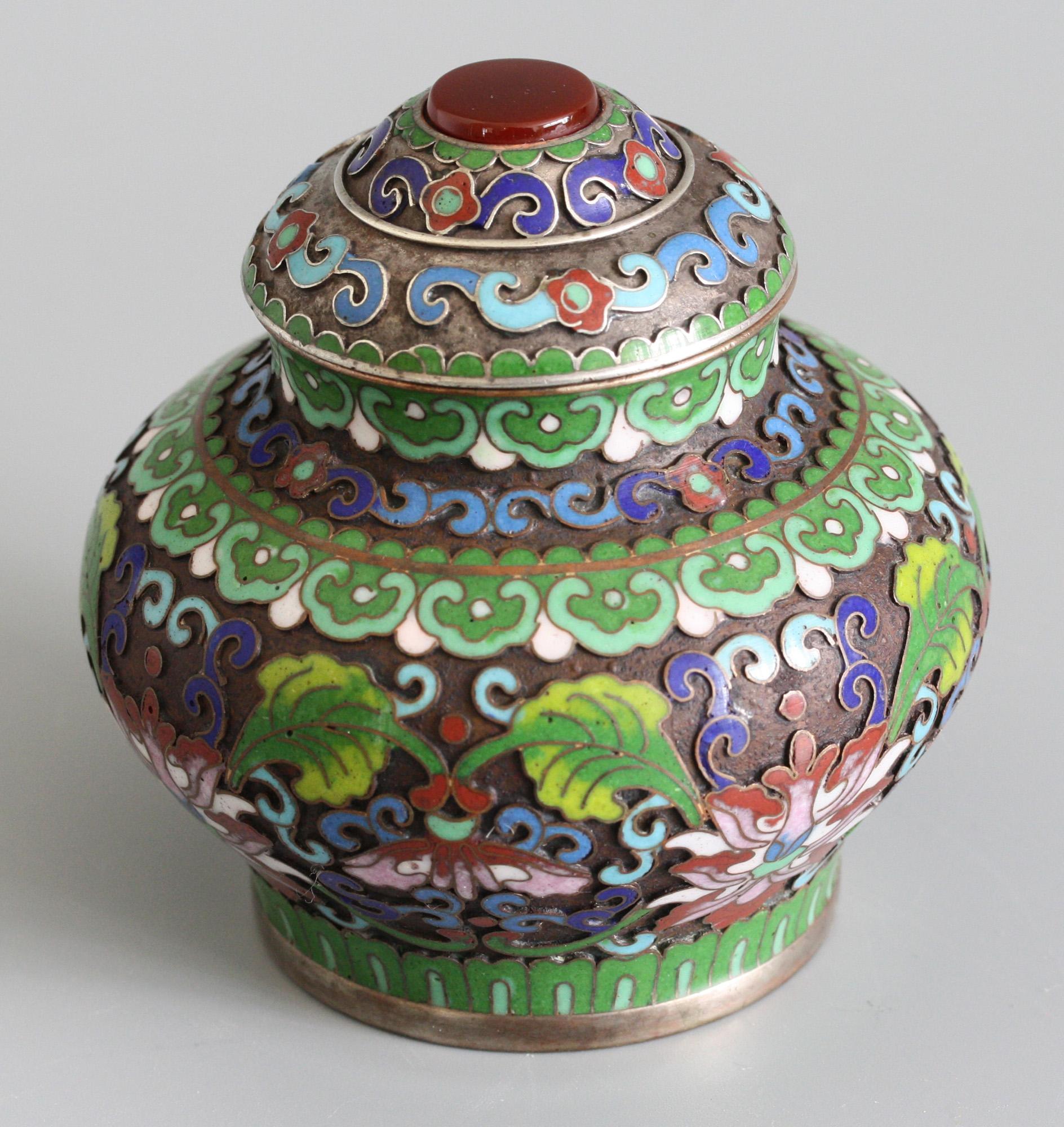 A very fine Chinese silver plated lidded cloisonne pot mounted with a polished carnelian dating from the early 20th century. This elegant pot stands on a narrow rounded base with a squat rounded body and short funnel neck with a fitted domed cover