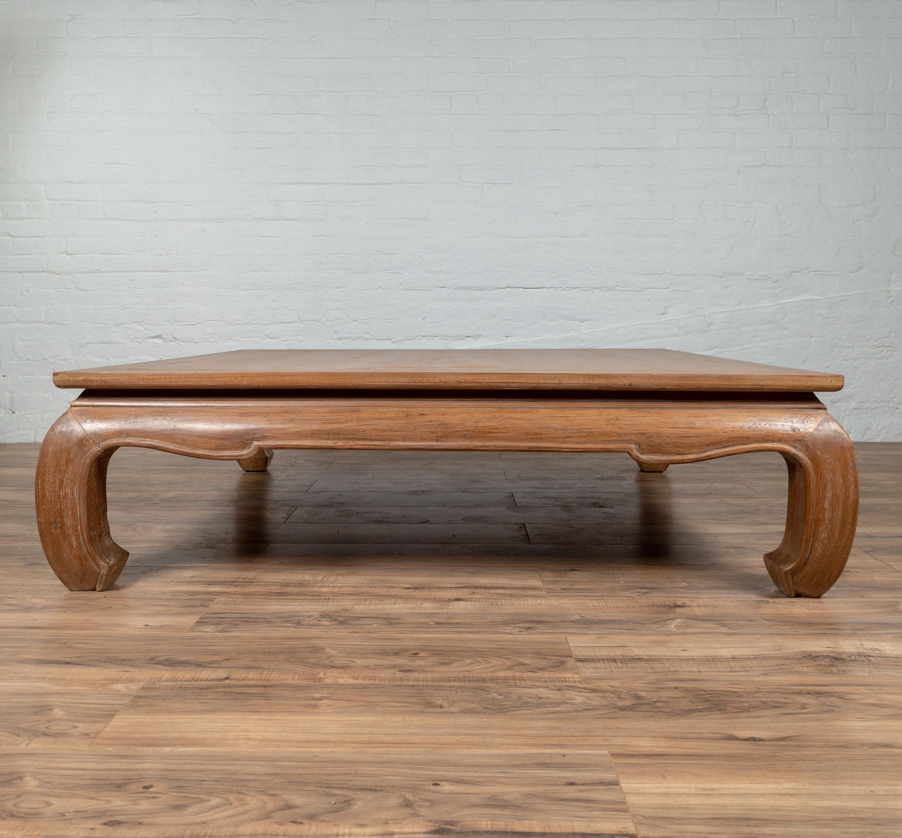 An antique Chinese coffee table from the early 20th century, with natural patina and bulging legs ending in horse-hoof feet. Born in China in the early years of the 20th century, this simple yet elegant coffee table features a square top with