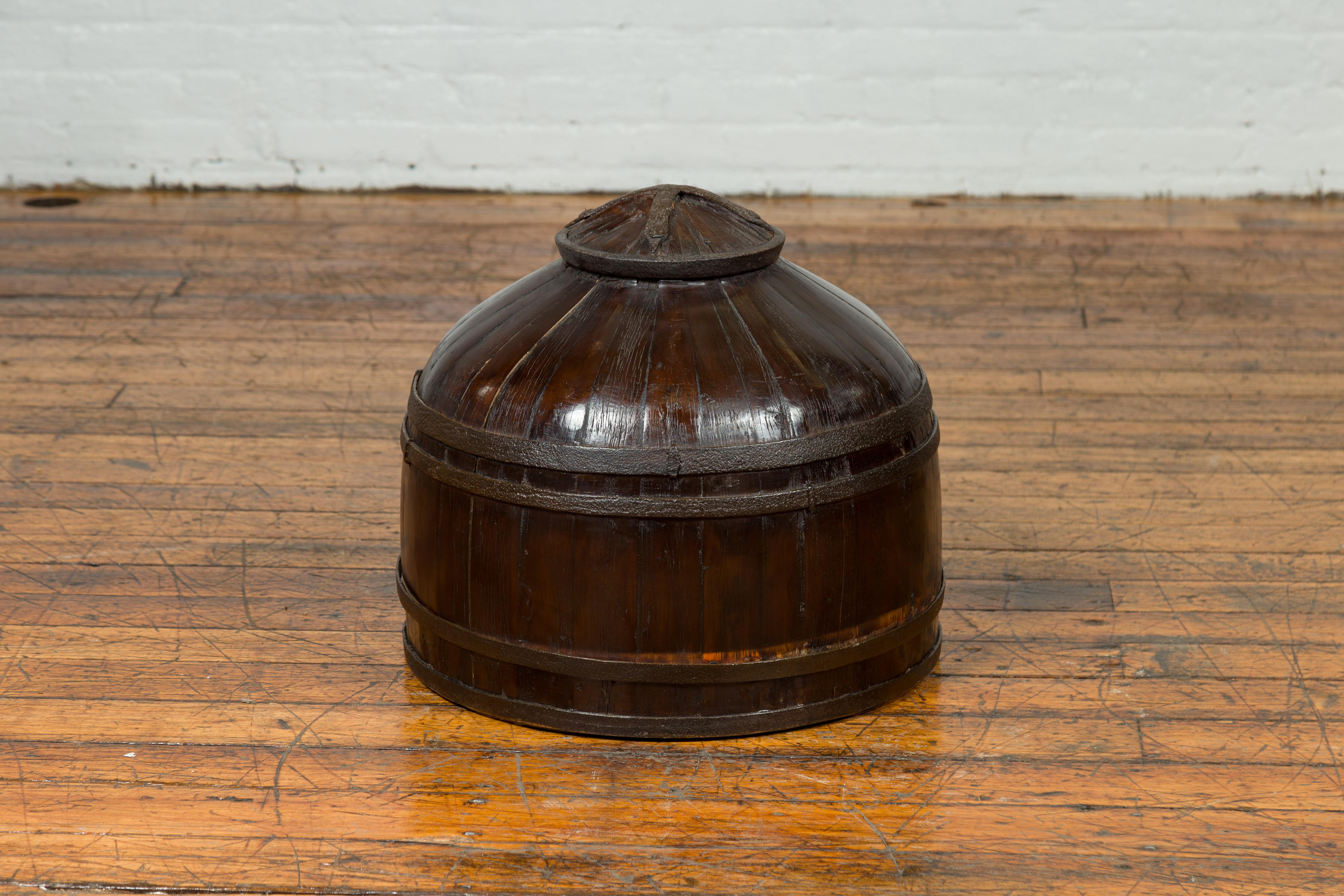 A Chinese antique decorative wooden cover from the 19th century. Charming us with its unusual shape and dark patina, this wooden cover which used to be part of a farmer's box, will make for an exquisite decorative accent in any home. Its conic shape