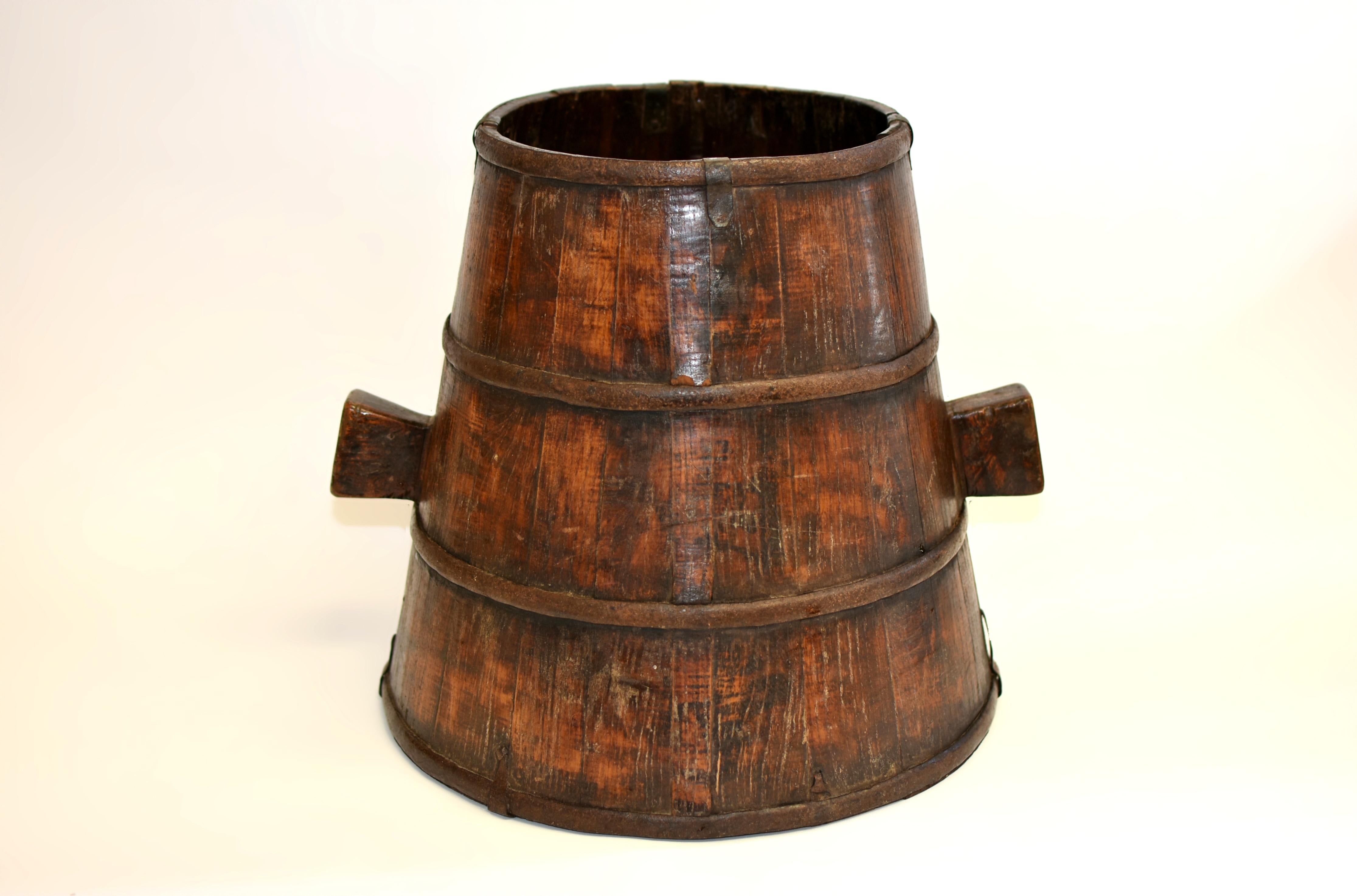 From Shanxi, this 19th century solid wood grain holder is entirely hand-crafted with superb workmanship. The basket is bound with four sturdy iron bands encircling its body, rim, and base, with the top and bottom further reinforced by iron brackets