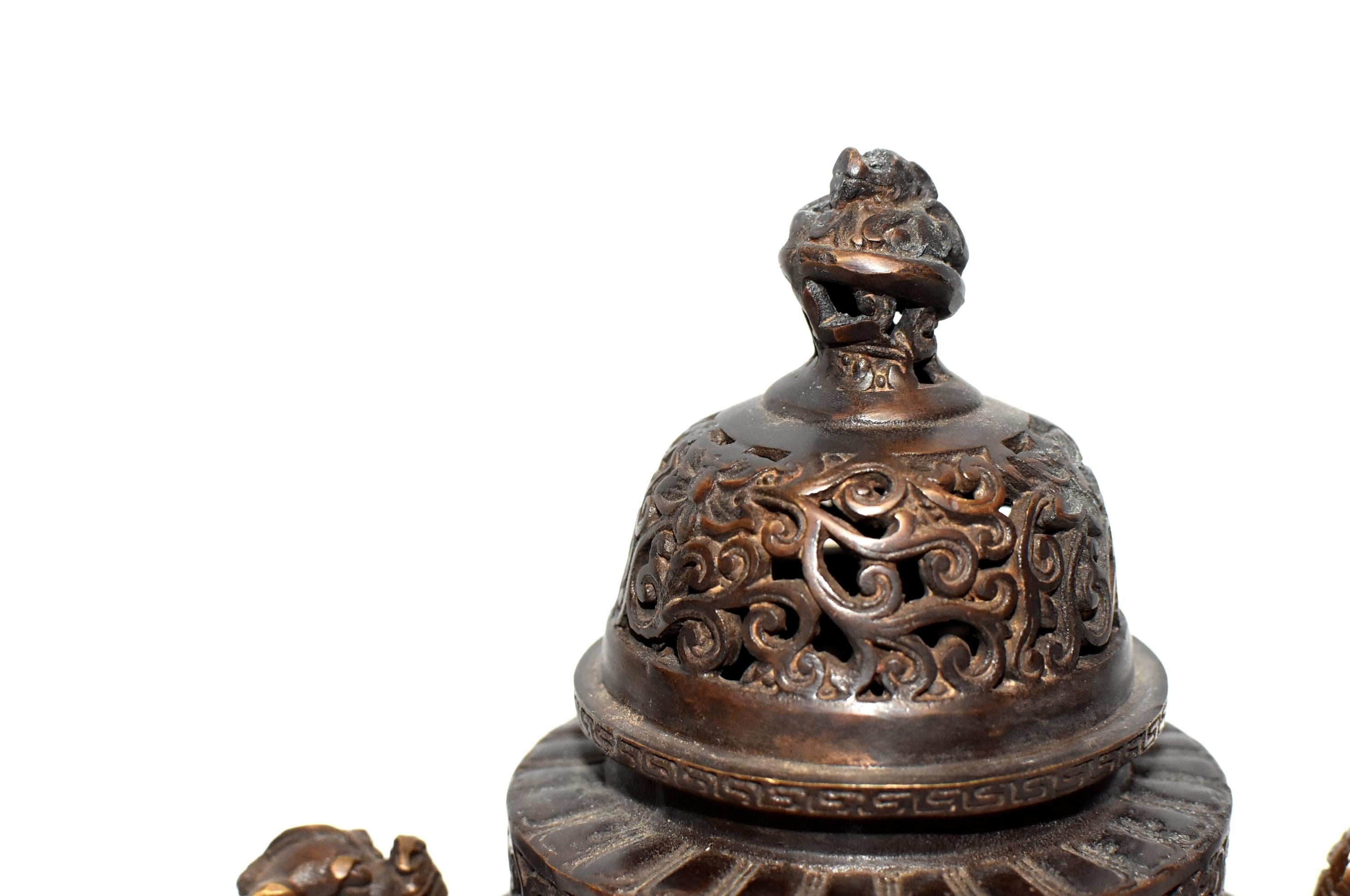 A fine, Chinese antique bronze incense burner. 3-foot, elaborately pierced top with a coiled dragon finial, 2-dragon handles, a round capacity body. Handmade. Signed Qing Qian Long Period, although we believe it is of a later day (19th century) make.