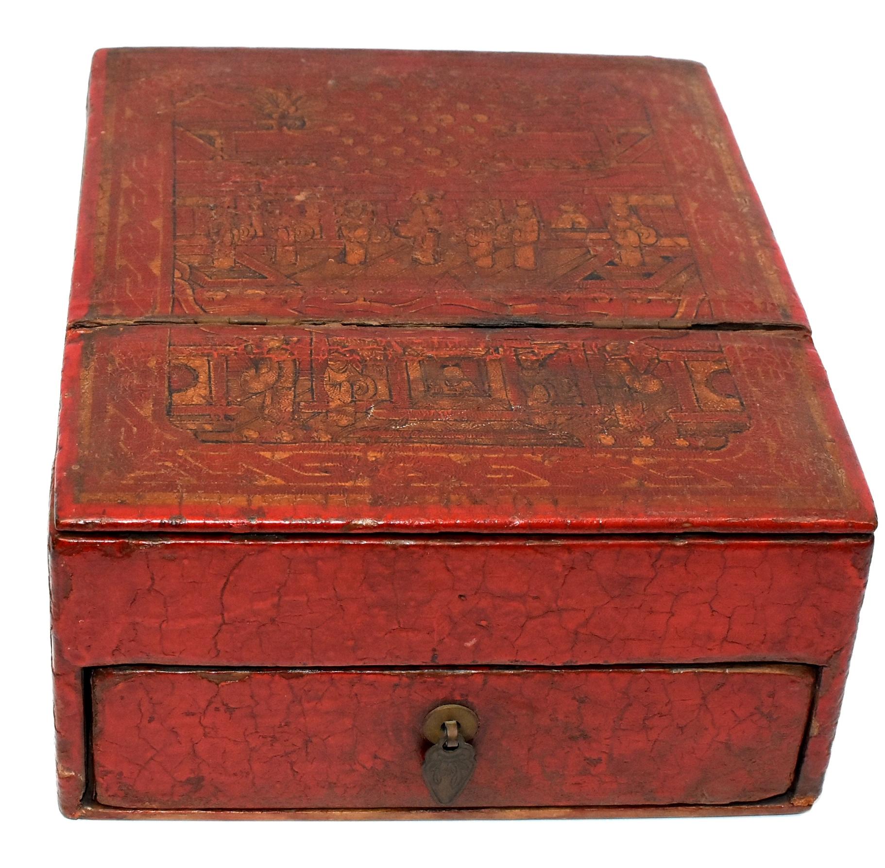 A beautiful old box made of wood and leather. The box has a painted top featuring hand painted scene of a happy gathering at a private estate. It has gilded figures and detailed depictions of architectures. One side of the box has gilded lotus, the