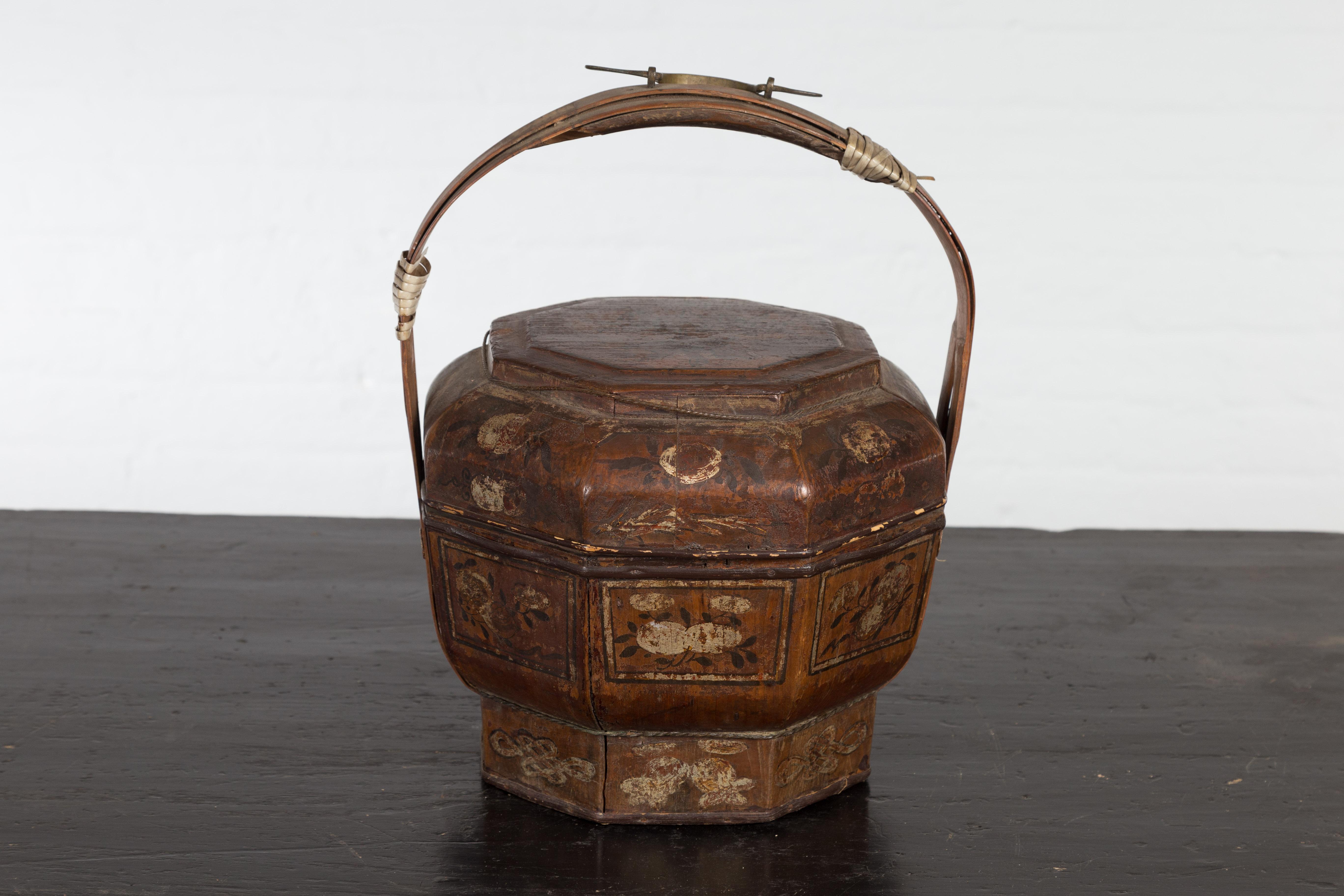 A Chinese late Qing Dynasty period antique lacquered octagonal basket from the early 20th century with hand painted floral décor, large handle and made to deliver gifts. Created in China during the late Qing Dynasty period in the early years of the
