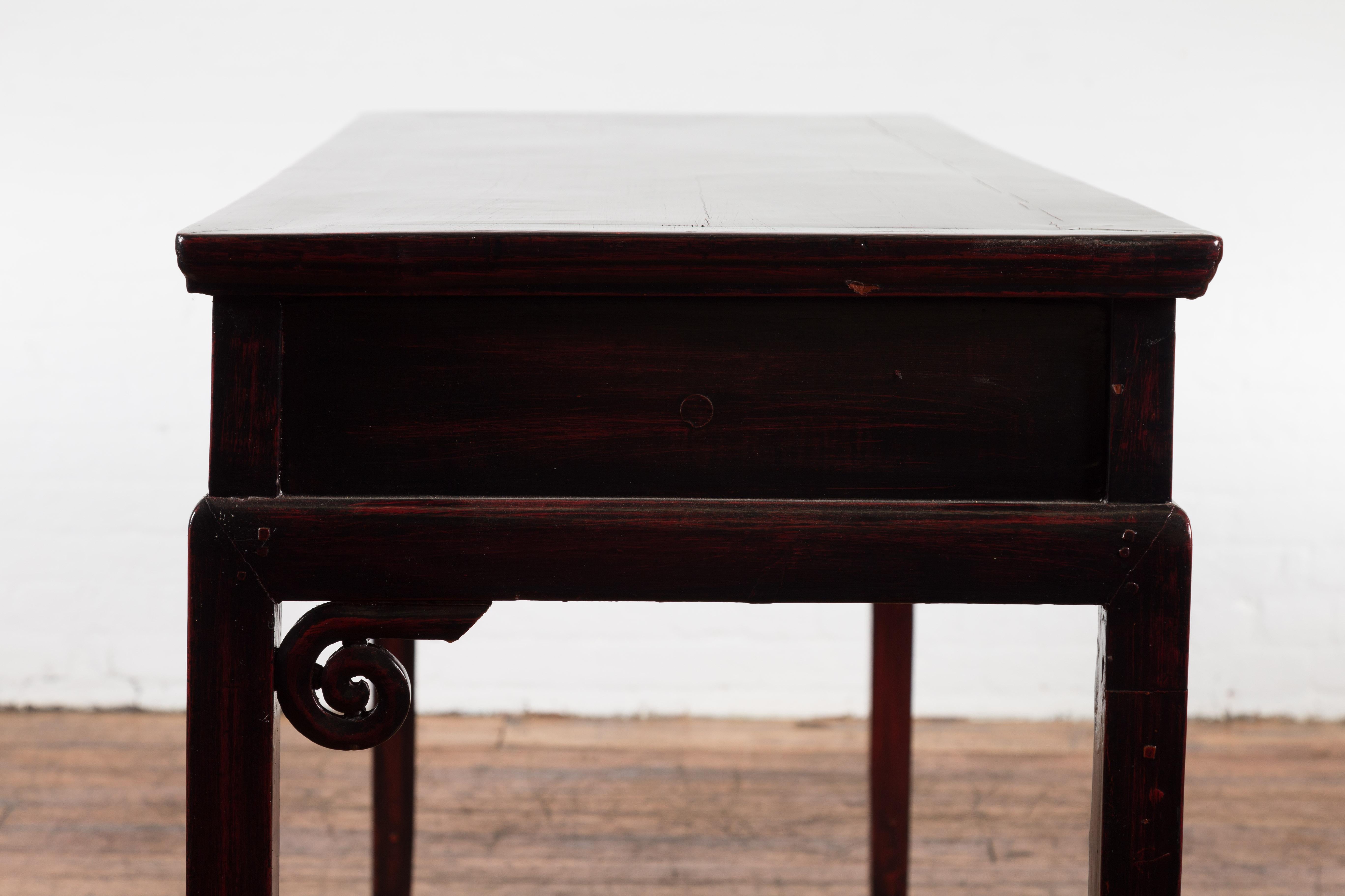 Bureau chinois ancien en bois laqué avec quatre tiroirs et volutes enroulées en vente 11