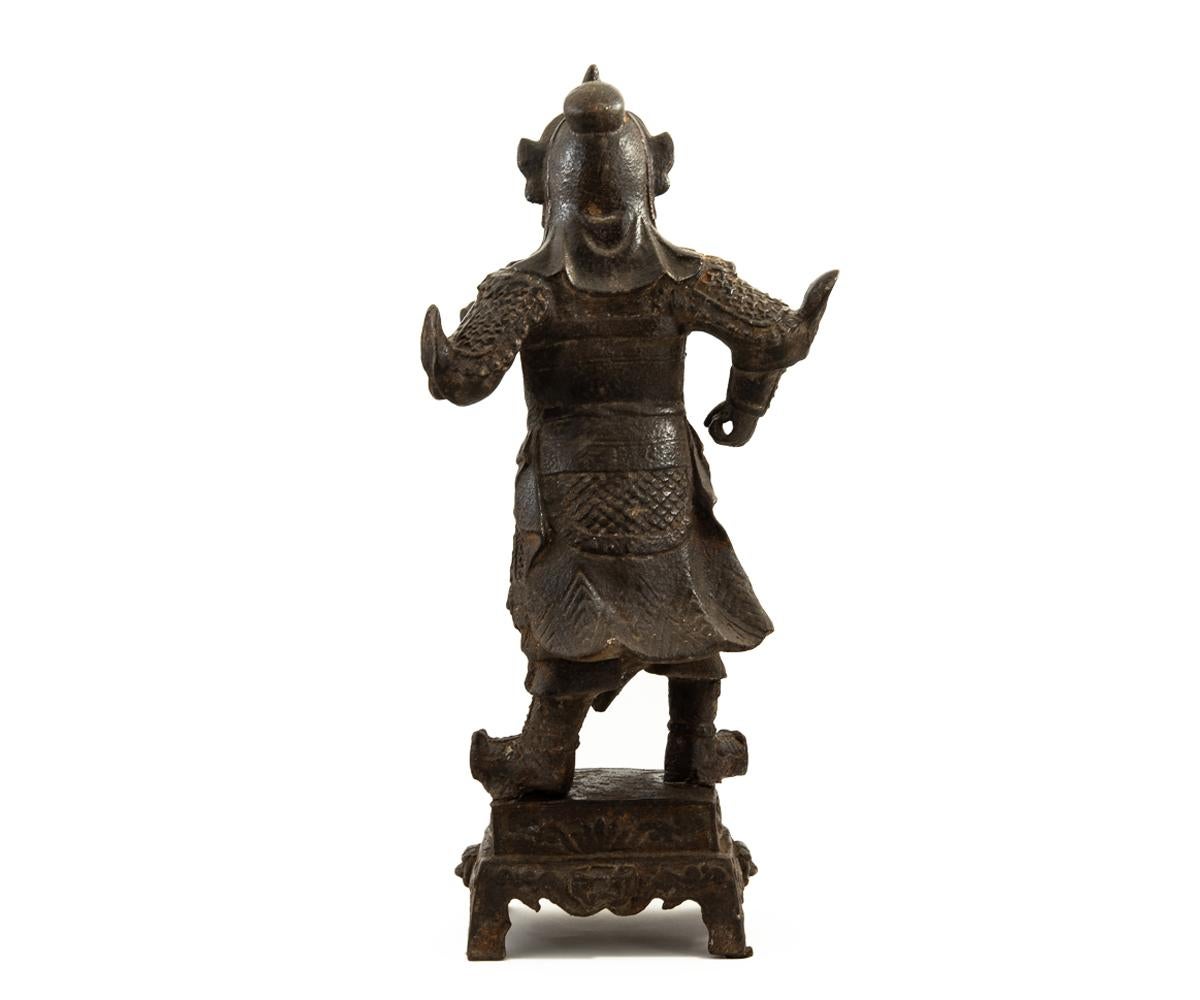Offered is this authentic Chinese antique Ming dynasty (1368-1644) iron figure depicting the deity, Guandi, standing in armored robes and donning his helmet while stroking his beard and standing upon a pedestal base with a four-character mark.